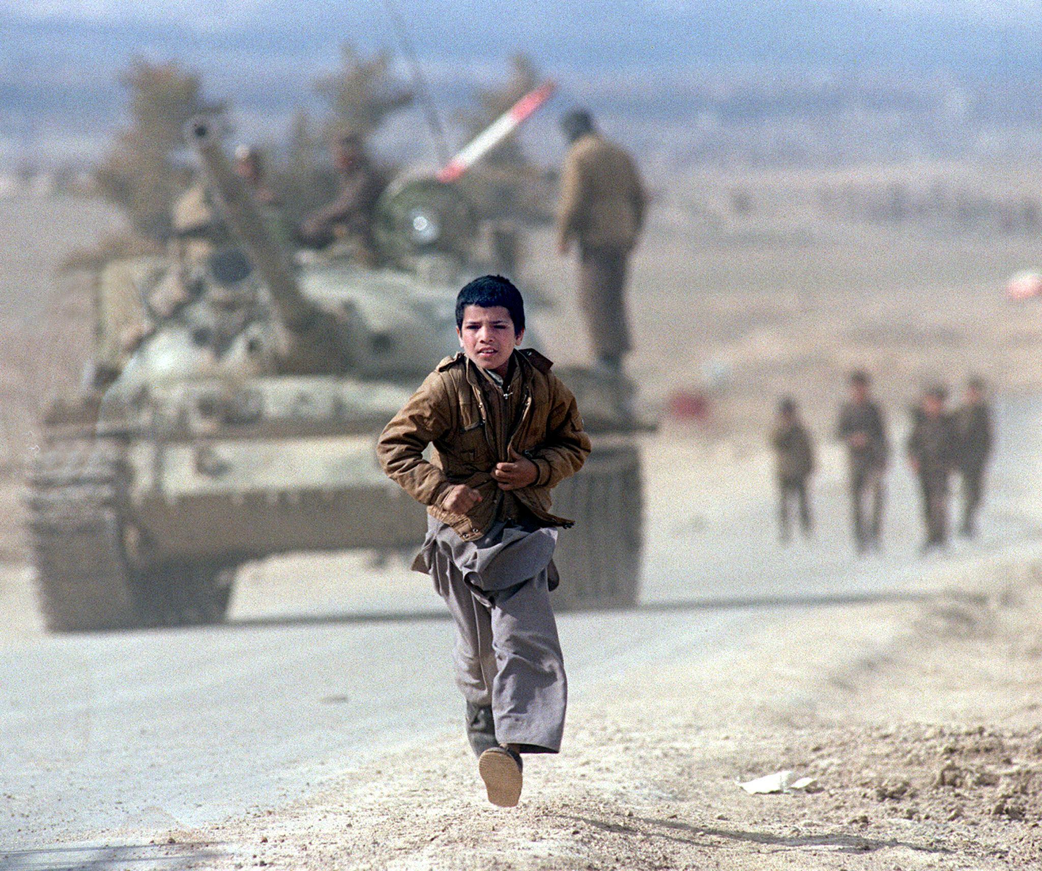 chłopiec biegnie po ulicy, w tle sowiecki czołg