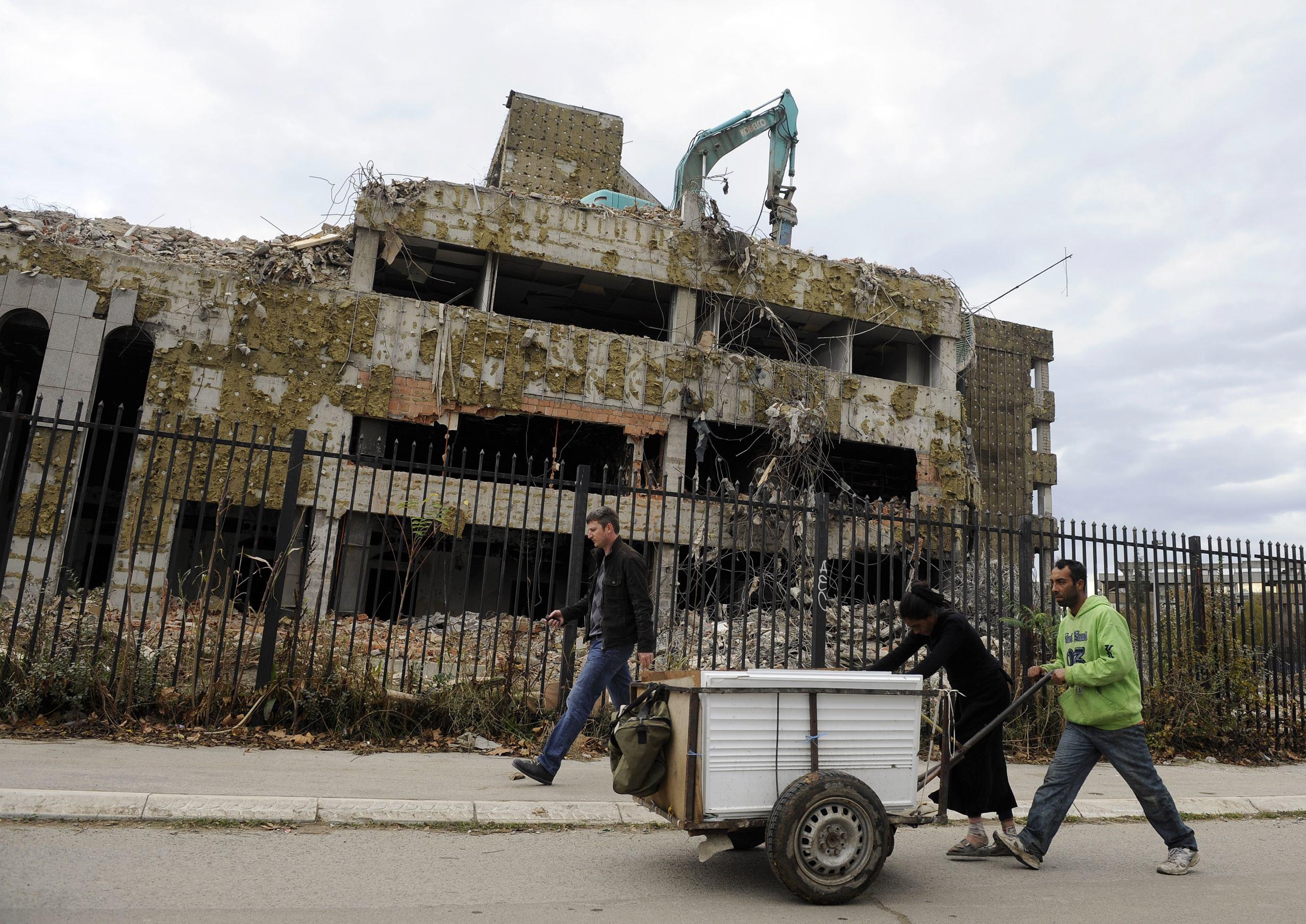 Pedestrians walk past the remains of the former Chinese Embassy in Belgrade,  on November 10, 2010. In 1999, the Chinese embassy in Belgrade,  was hit and set on fire during Nato air strikes on the city.   AFP PHOTO / Andrej ISAKOVIC (Photo by ANDREJ ISAKOVIC / AFP)