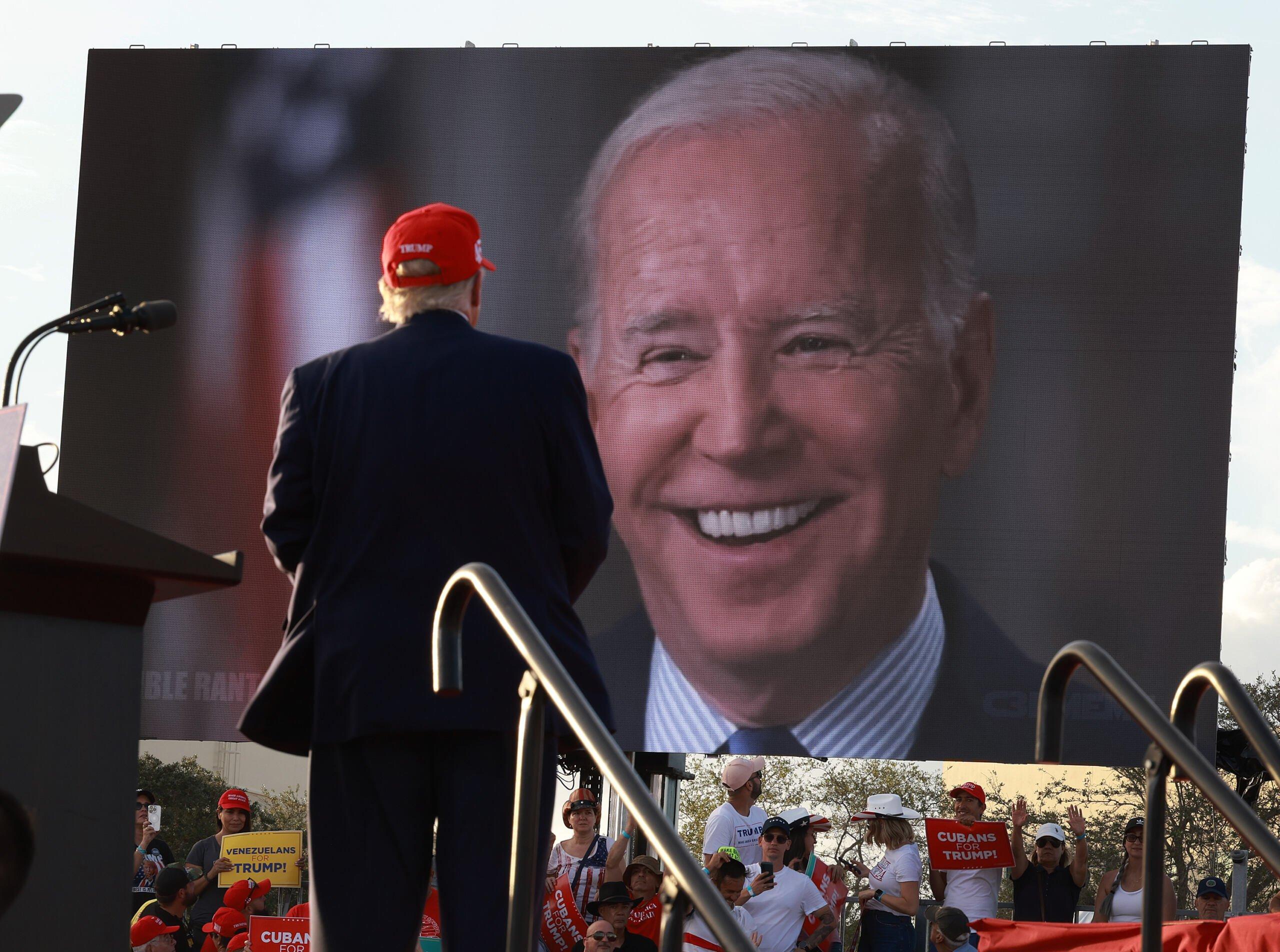 MIAMI, FLORIDA - NOVEMBER 06: Former U.S. President Donald Trump watches a video of President Joe Biden playing during a rally for Sen. Marco Rubio (R-FL) at the Miami-Dade Country Fair and Exposition on November 6, 2022 in Miami, Florida. Rubio faces U.S. Rep. Val Demings (D-FL) in his reelection bid in Tuesday's general election.   Joe Raedle/Getty Images/AFP (Photo by JOE RAEDLE / GETTY IMAGES NORTH AMERICA / Getty Images via AFP)