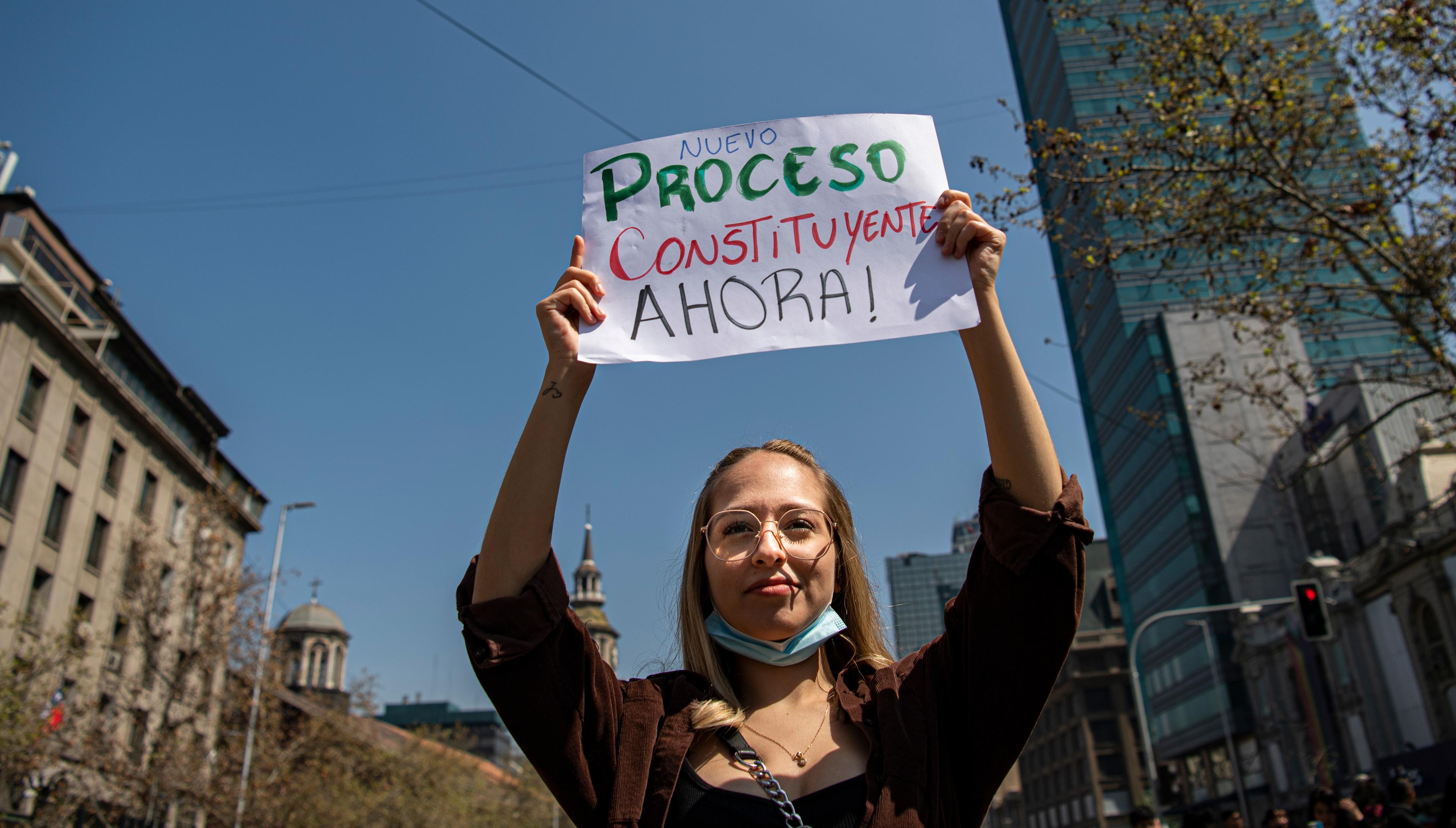 A student takes part in a demonstration to demand a new Constituent Assembly process, in the surroundings of La Moneda Presidential Palace in Santiago, on September 14, 2022. - Earlier this month, Chileans overwhelmingly rejected a draft constitution that would have replaced the constitution adopted during Augusto Pinochet's dictatorship. (Photo by Martin BERNETTI / AFP)