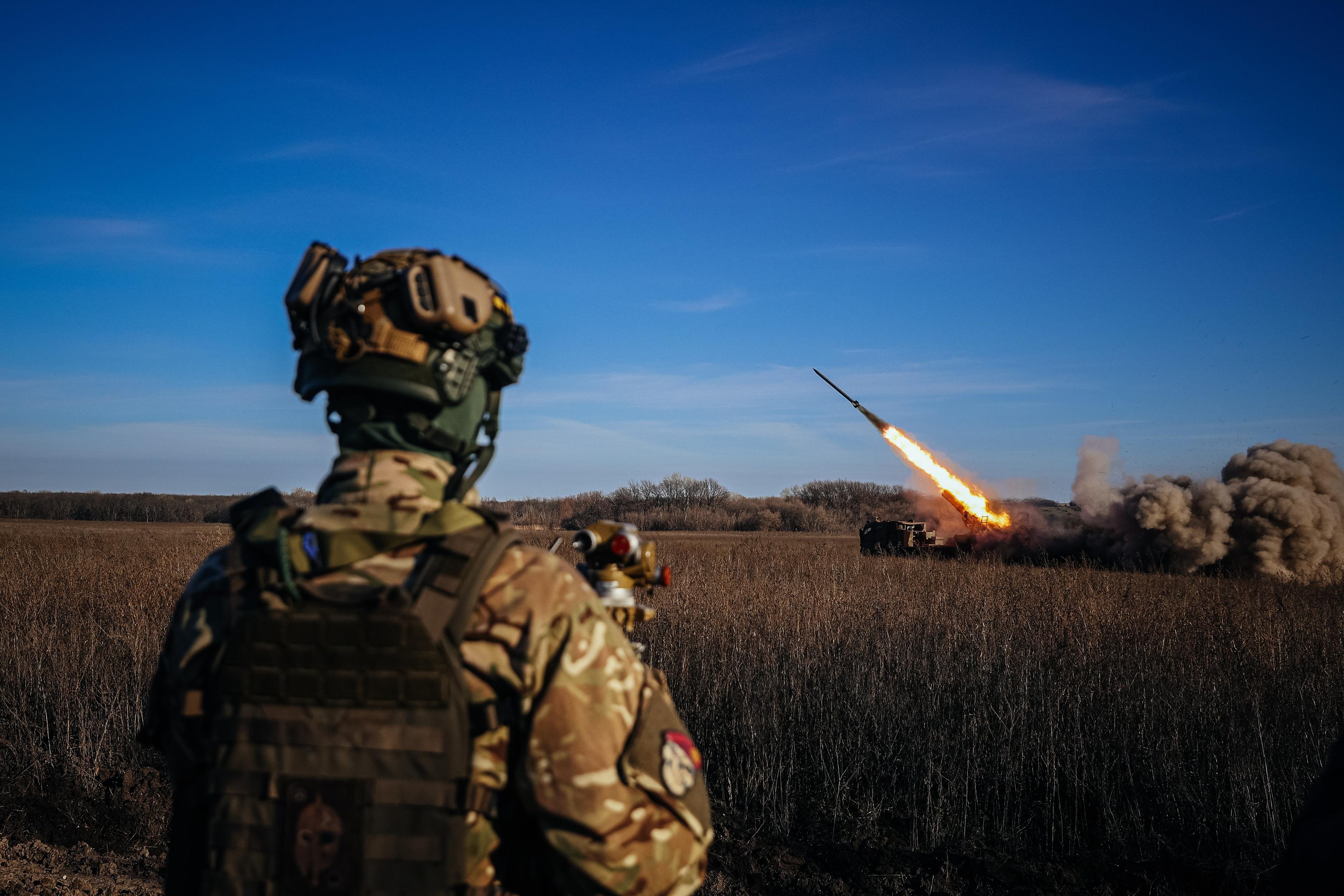 A Ukrainian soldier watches a self-propelled 220 mm multiple rocket launcher "Bureviy" firing towards Russian positions on the front line, eastern Ukraine on November 29, 2022, amid the Russian invasion of Ukraine. (Photo by ANATOLII STEPANOV / AFP)