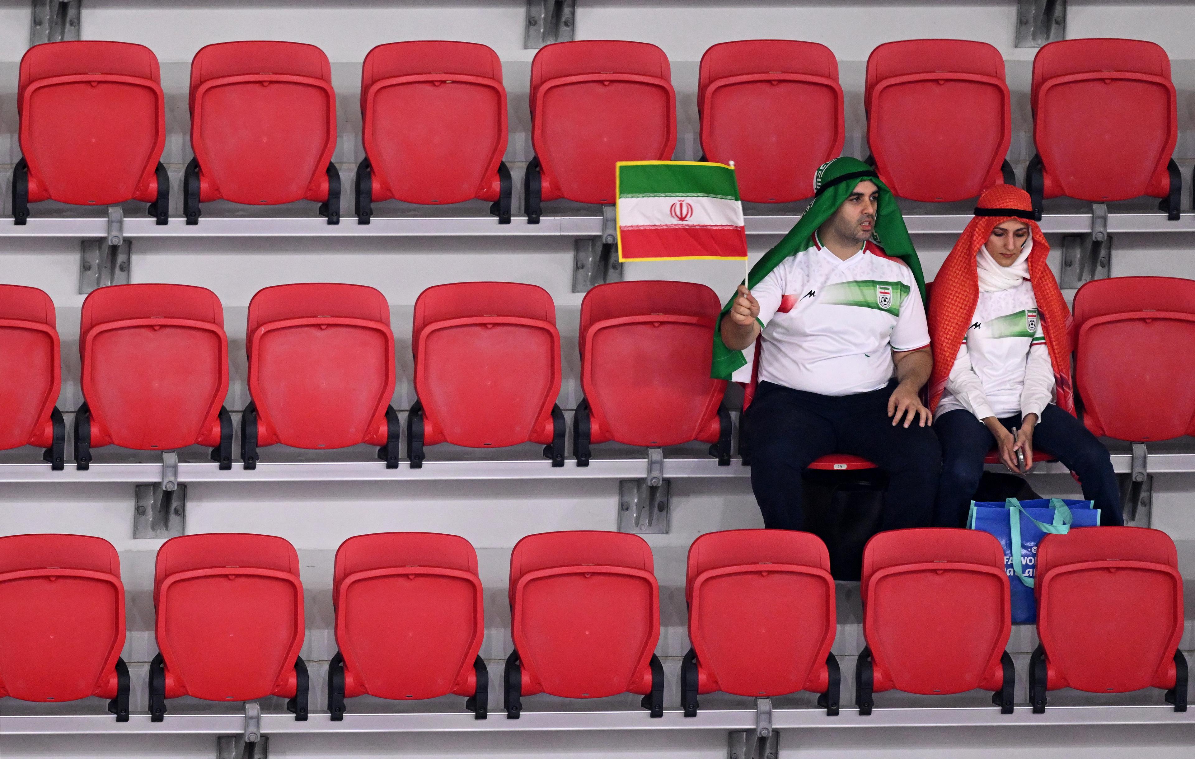 Iran fans wave an Iranian flag as they wait in their seats for kick off ahead of the Qatar 2022 World Cup Group B football match between Iran and USA at the Al-Thumama Stadium in Doha on November 29, 2022. (Photo by Kirill KUDRYAVTSEV / AFP)