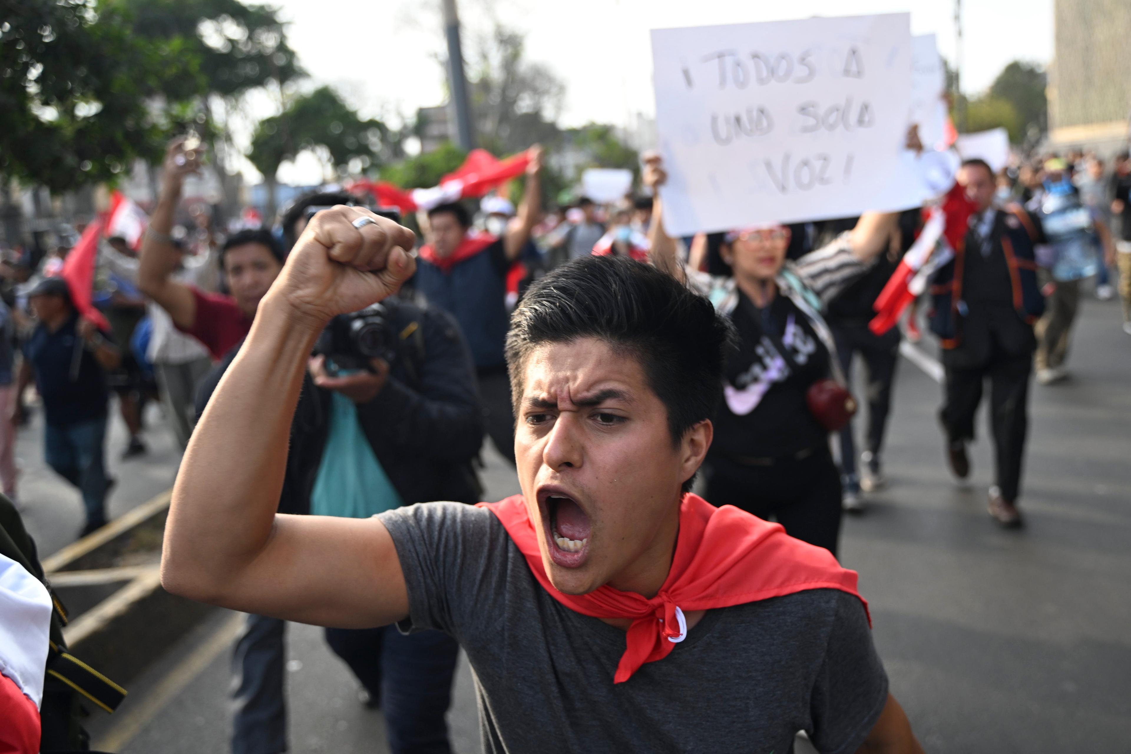 Supporters of former President Pedro Castillo shout slogans during a protest near the Congress in Lima on December 12, 2022. - Two more protesters died in Peru on Monday during demonstrations against the ousting of former president Pedro Castillo, the rights ombudsman said. (Photo by ERNESTO BENAVIDES / AFP)