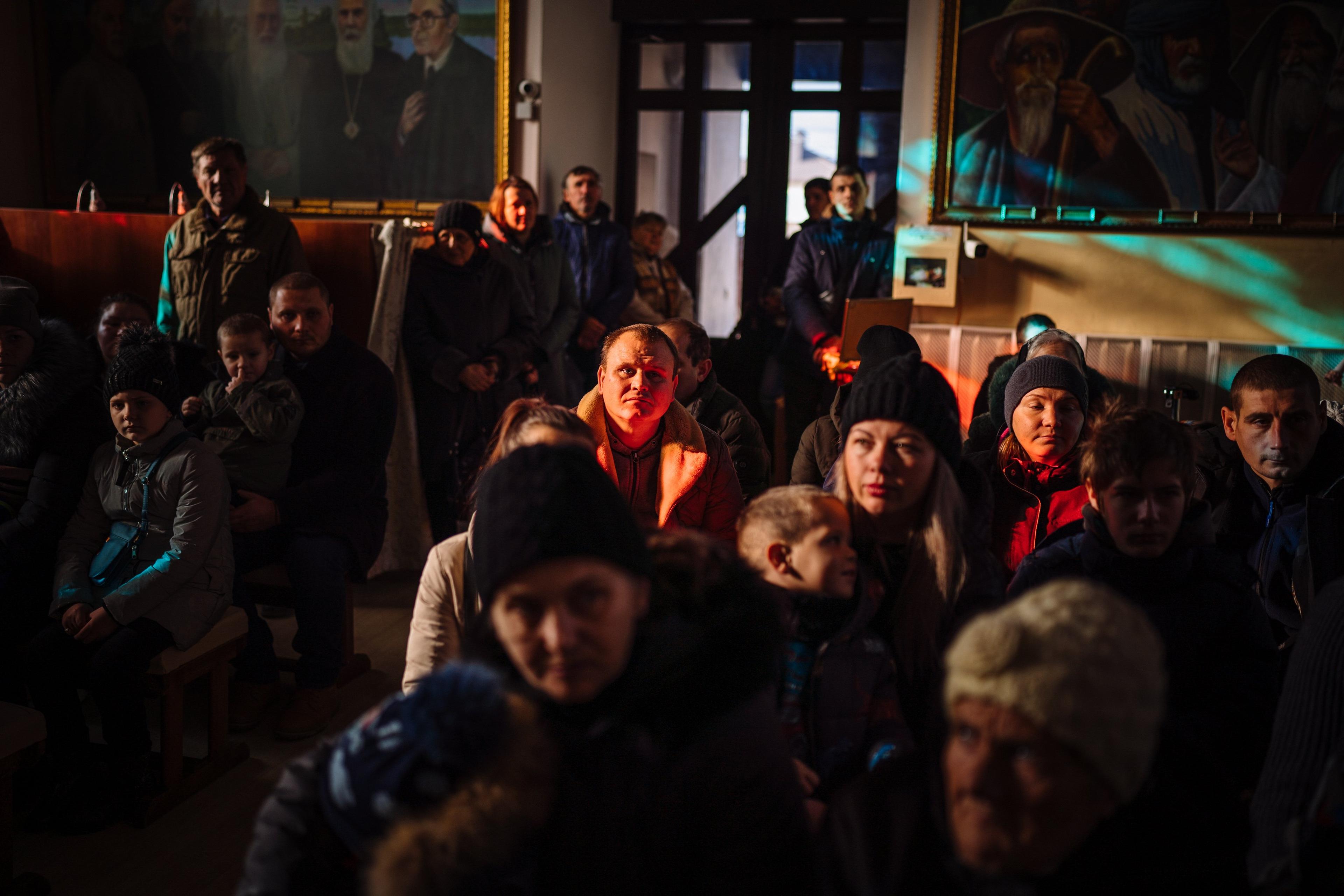 Ukrainian Orthodox Christian believers attend a St. Mykola (St. Nicolas) mass in a church in Kherson, on December 19, 2022, amid the Russian invasion of Ukraine. (Photo by Dimitar DILKOFF / AFP)