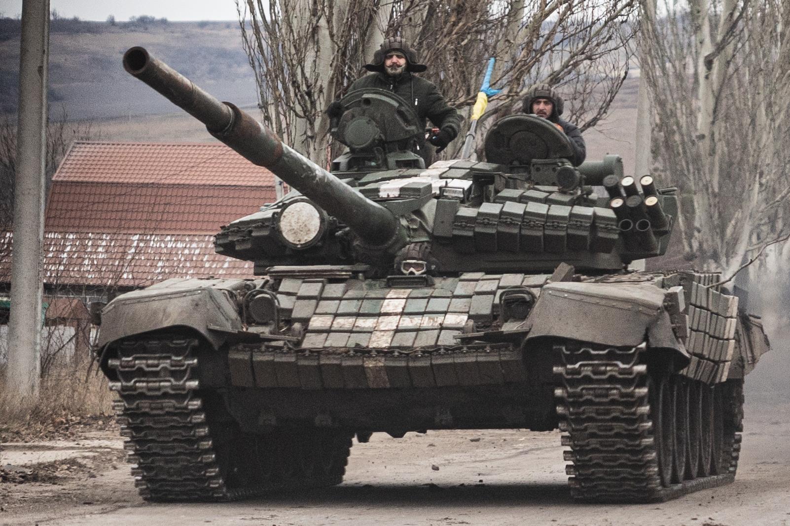 Ukrainian armed forces' soldiers drive a T-72 tank on the outskirts of Bakhmut, eastern Ukraine on December 21, 2022. - For civilians trying to survive in the hell of Bakhmut, the visit of Ukrainian President Volodymyr Zelensky on December 20, 2022 was a non-event. But it boosted the morale of soldiers engaged in one of the most violent battles on the front line. (Photo by Sameer Al-DOUMY / AFP)