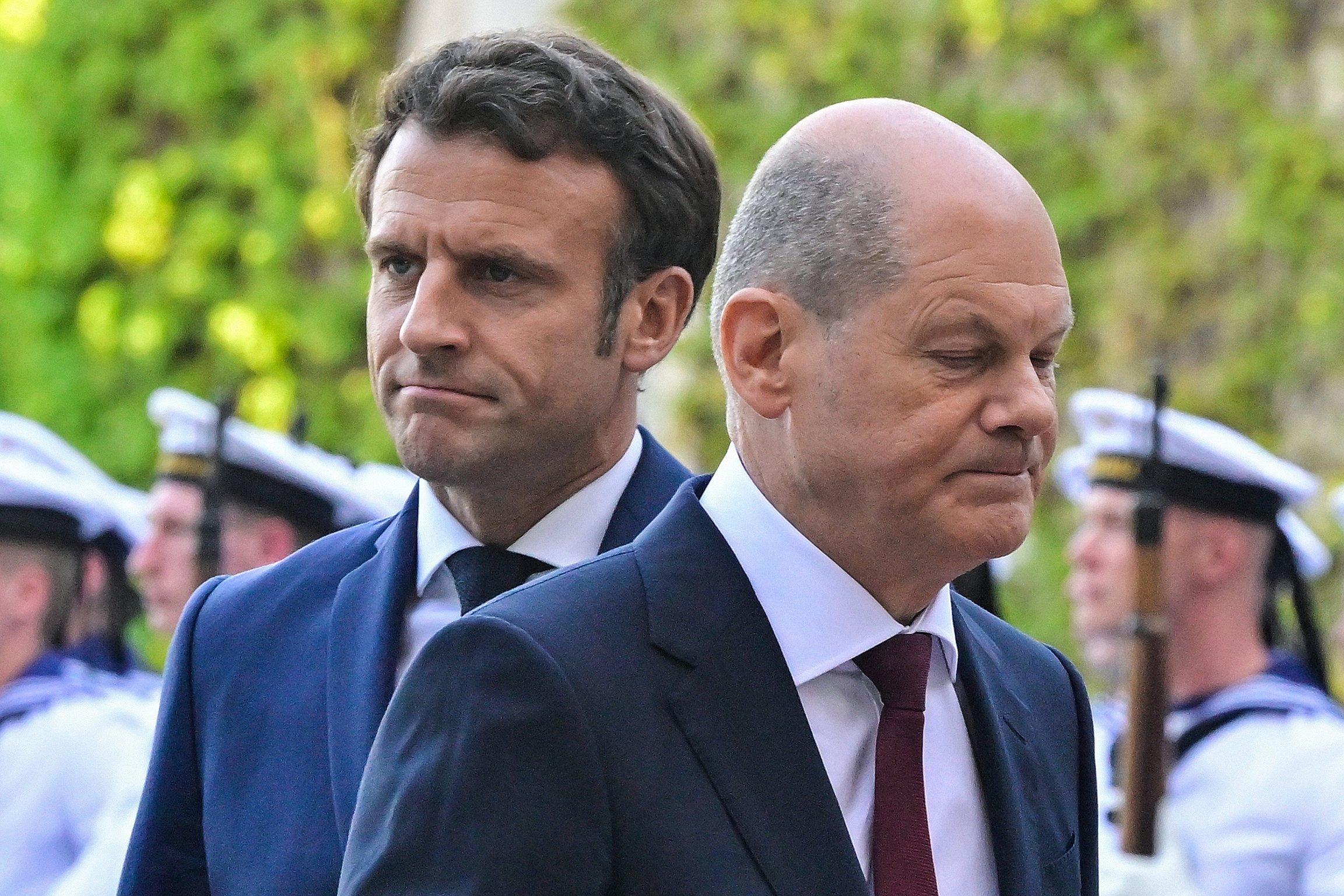 (FILES) In this file photo taken on May 9, 2022 German Chancellor Olaf Scholz (R) and French President Emmanuel Macron make their way inside after inspecting an honor guard during a welcome ceremony at the Chancellery in Berlin. - A war in his backyard, galloping economic crisis, and unhappy partners at home and abroad -- German Chancellor Olaf Scholz has weathered unprecedented shocks in his first year while struggling to make a mark on the global stage. (Photo by John MACDOUGALL / AFP) / NO USE AFTER JANUARY 1, 2023 15:45:50 GMT - ALTERNATIVE CROP  - ALTERNATIVE CROP