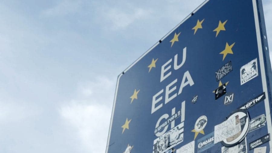 Niebieska tablica graniczna Unii Europejskiej na tle nieba