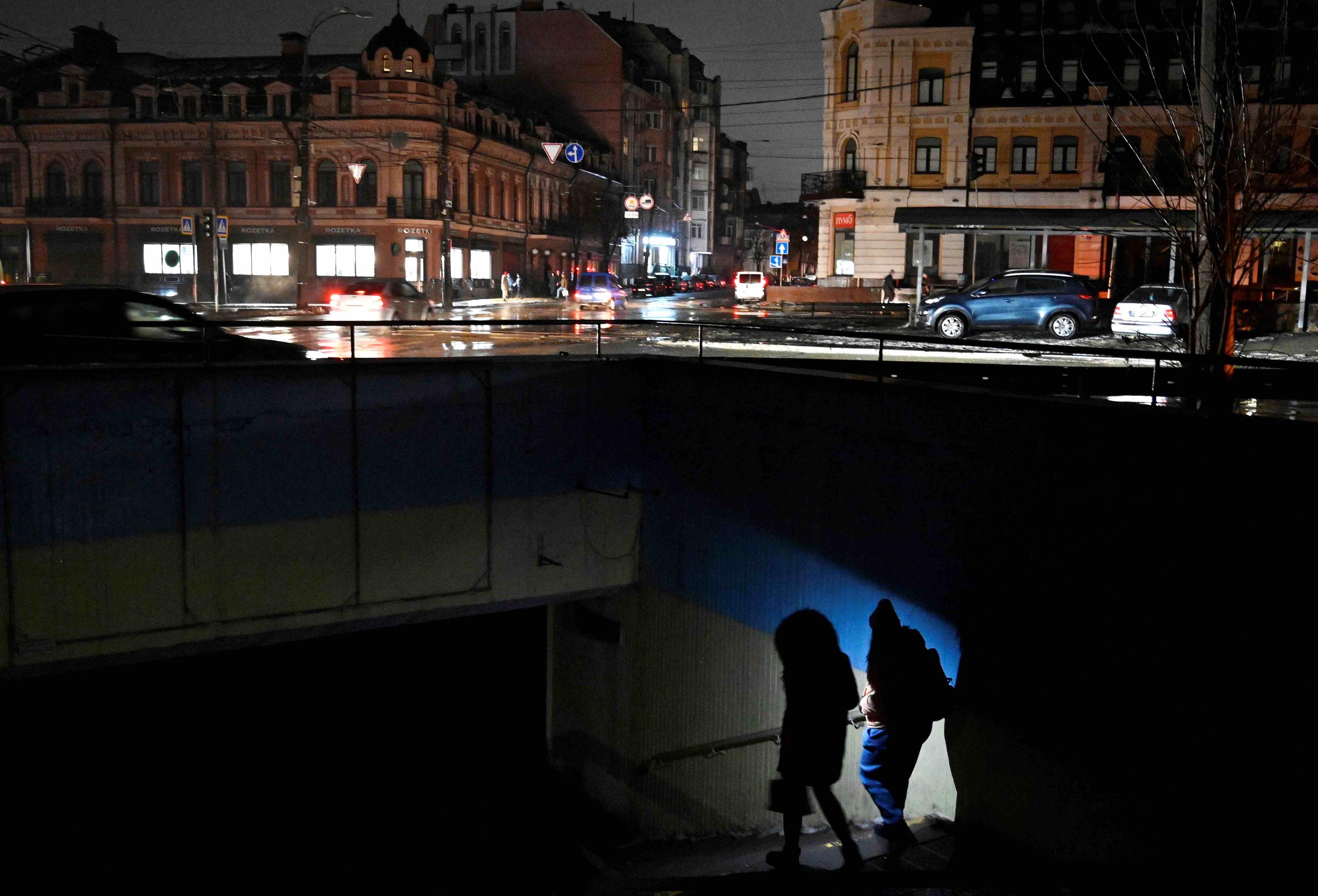 Para schodzi do metra, oświetlając sobie drogę latarką