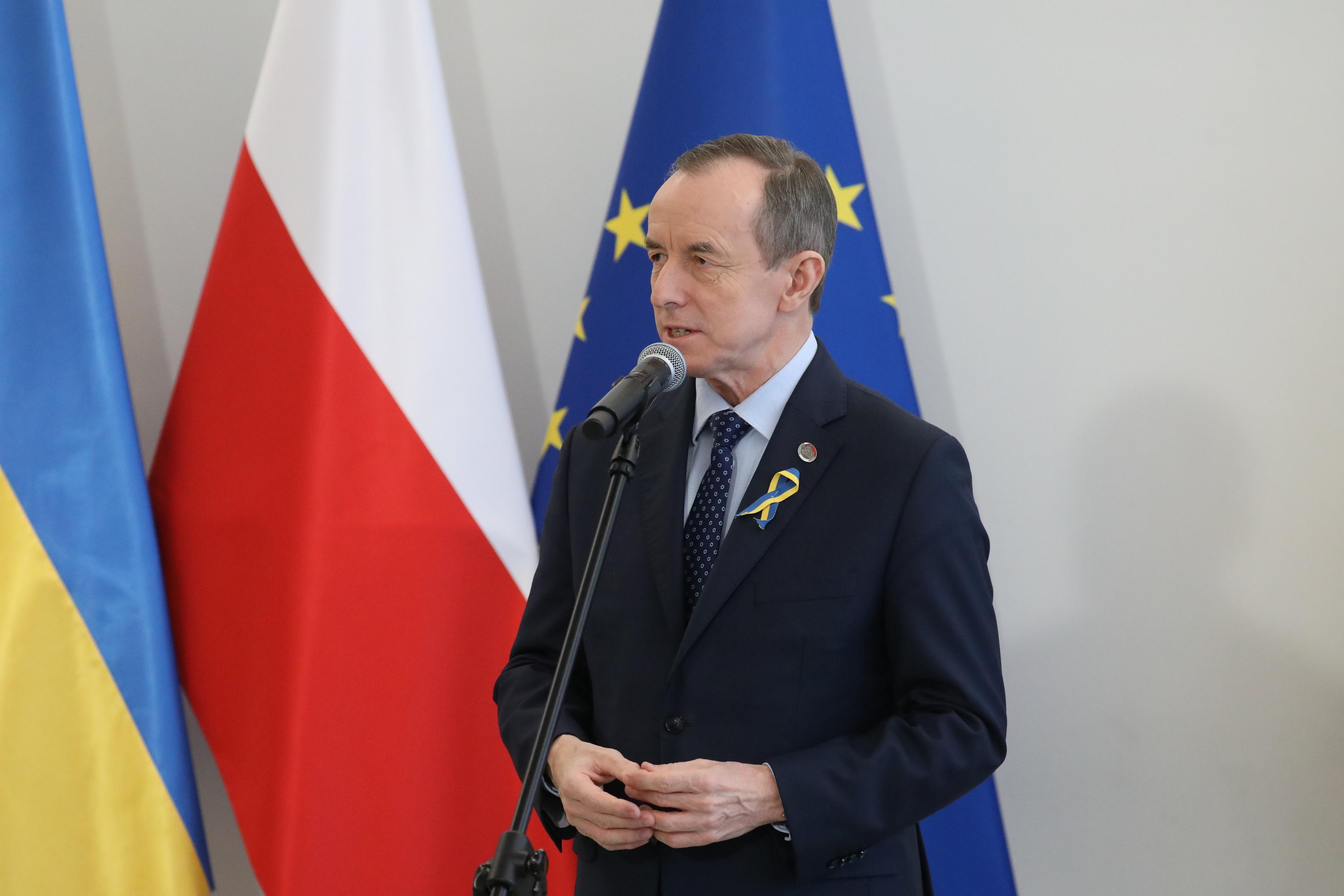 Marszałek Senatu Tomasz Grodzki na tle flag Ukrainy, Polski i Unii Europejskiej