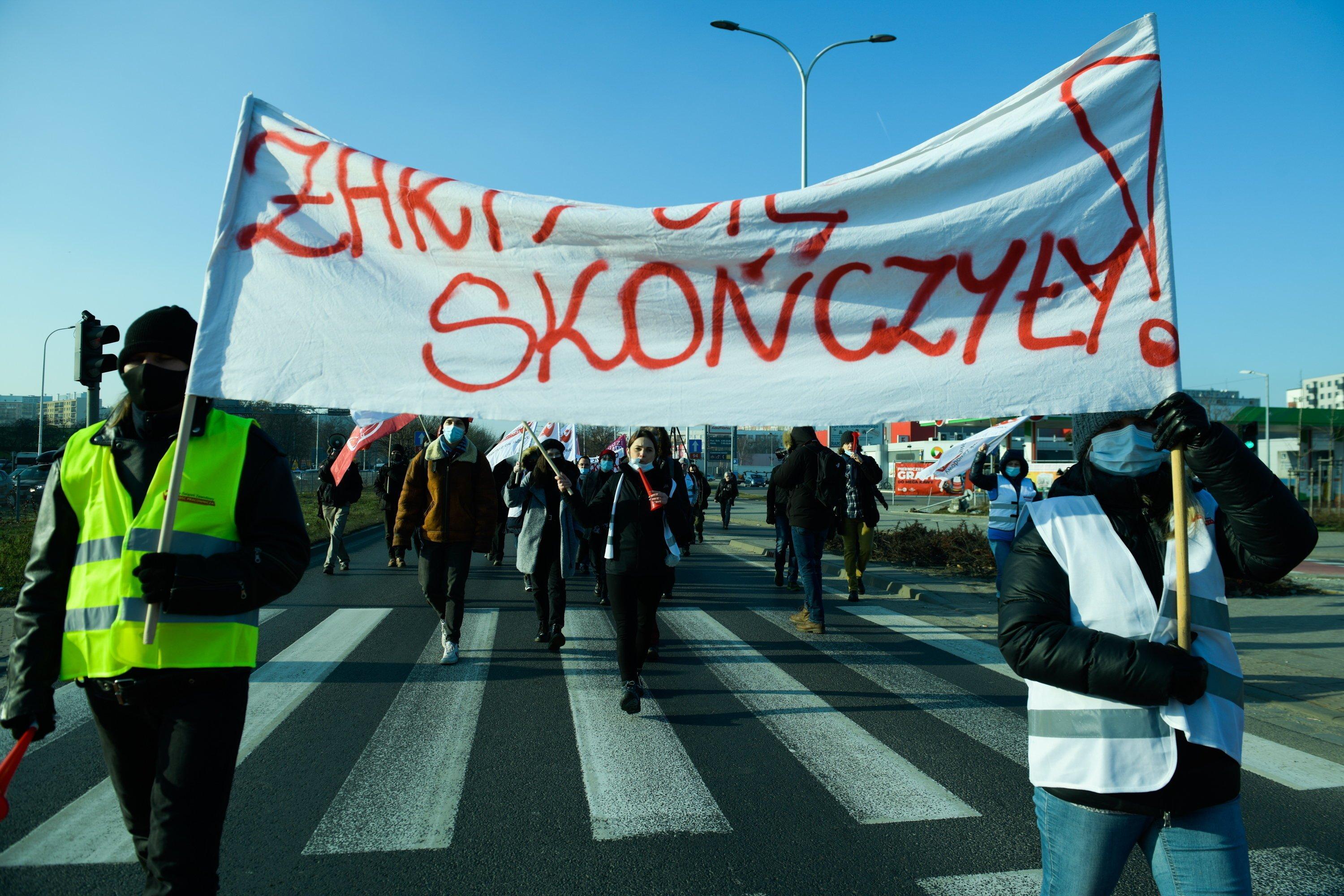 Dwóch protestujących trzyma transparent z napisem "żarty się skończyły"