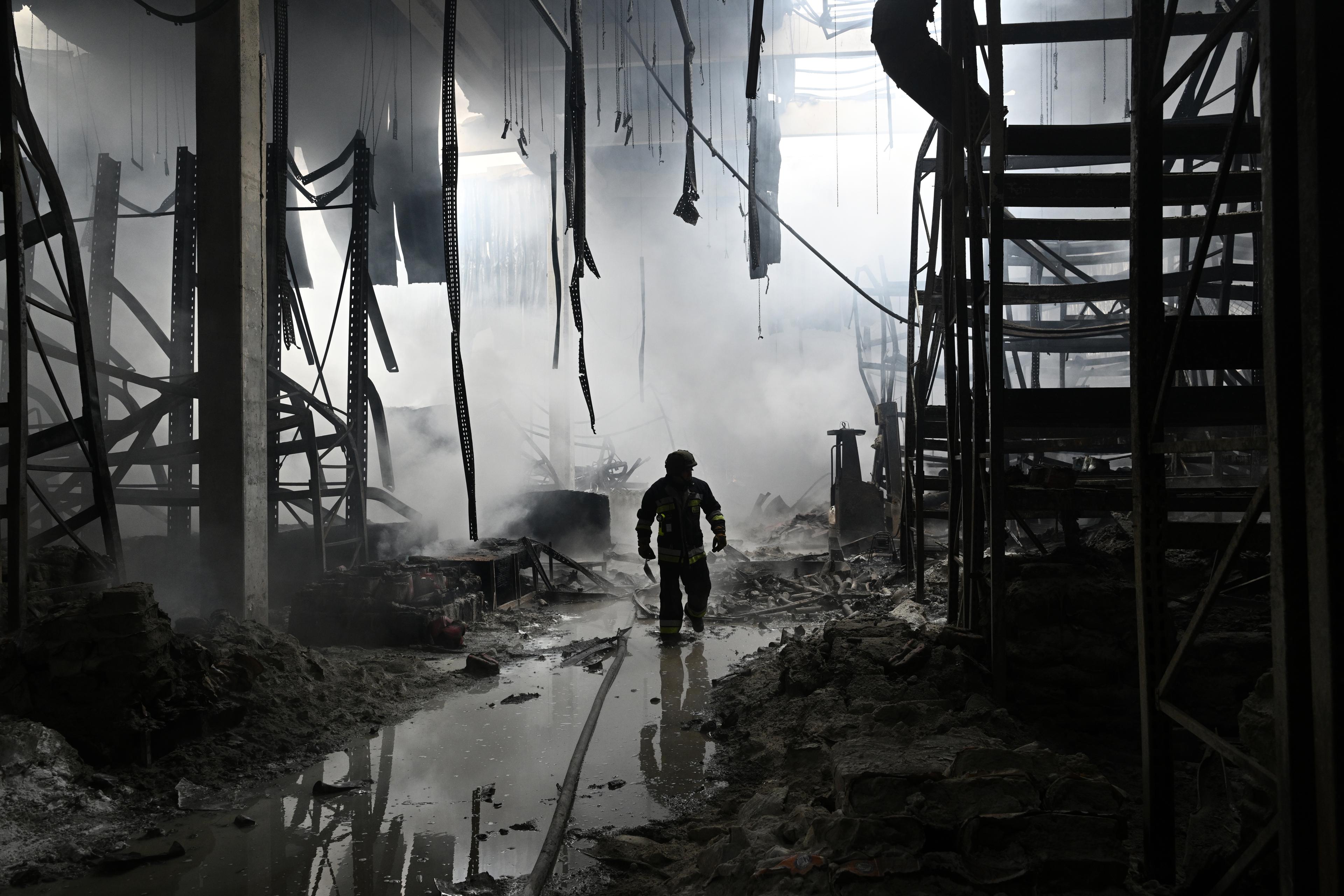 strażak wśród ruin zbombardowanego centrum handlowego