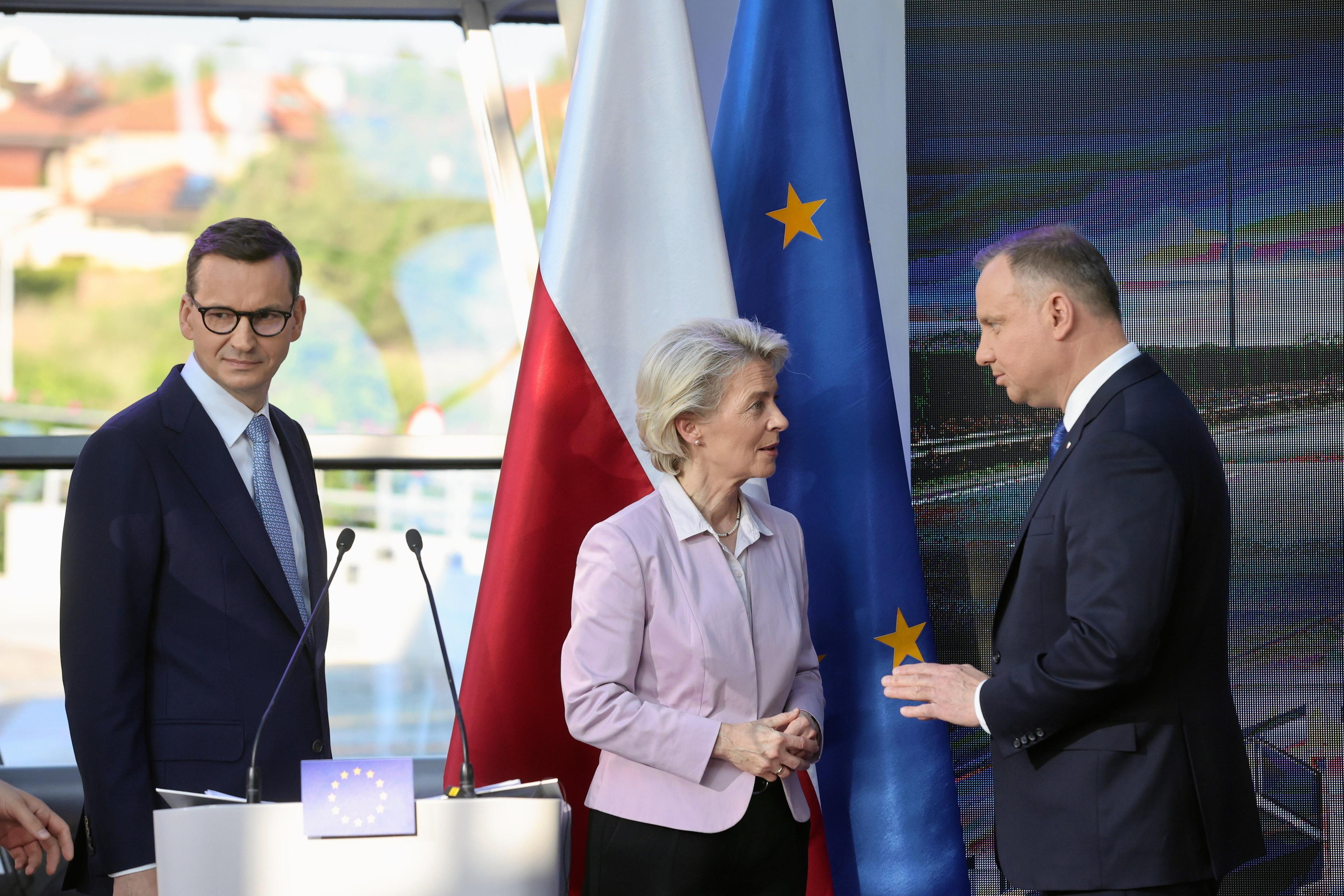 Premier Morawiecki, URsula von der Leyen i prezydent Duda rozmawiają. Przed nimi mównica, za nimi flagi Polski oraz Unii Europejskiej