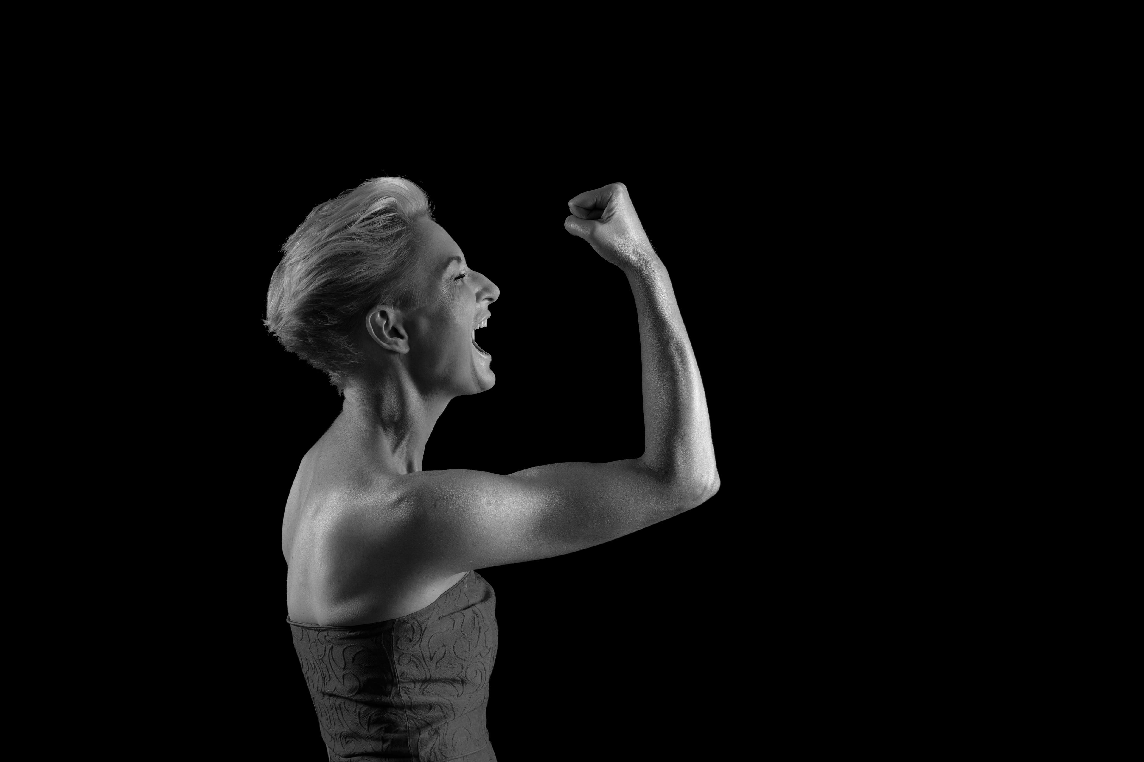 Portret kobiety, napinającej biceps