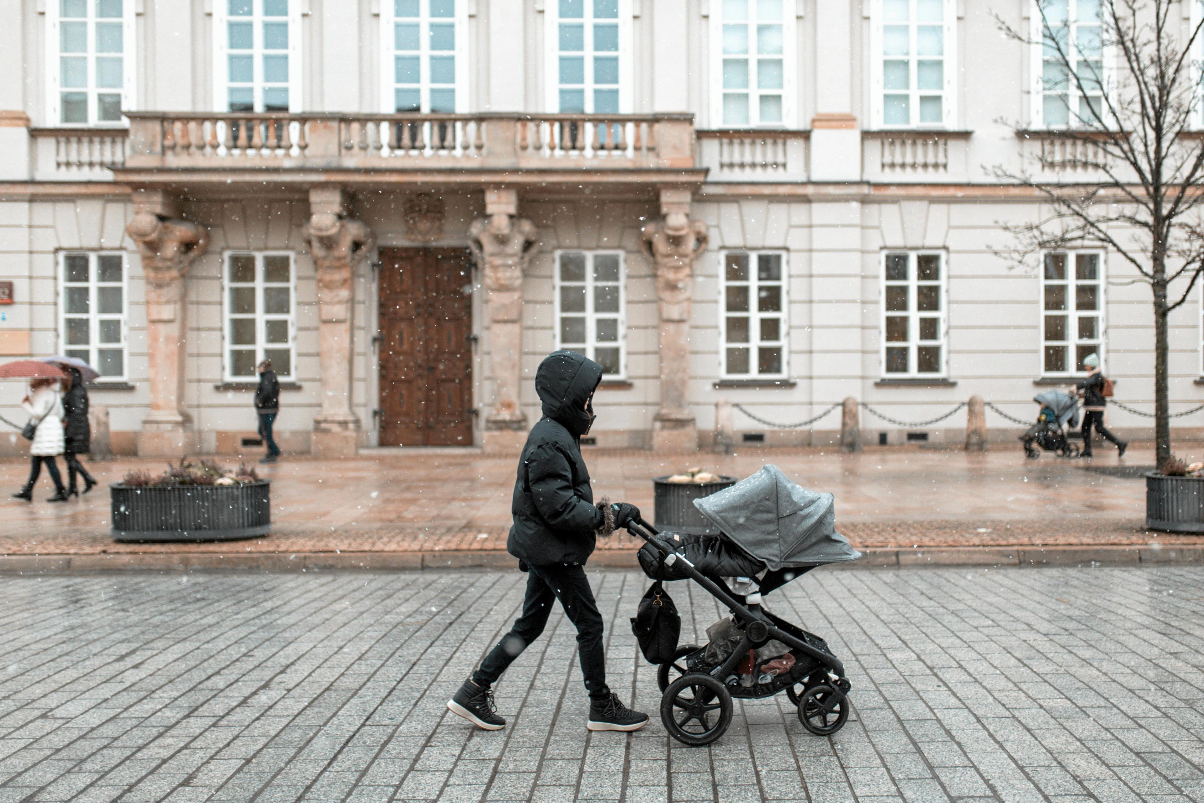Kobieta z dzieckiem w wózku na ulicy Krakowskie Przedmieście w Warszawie