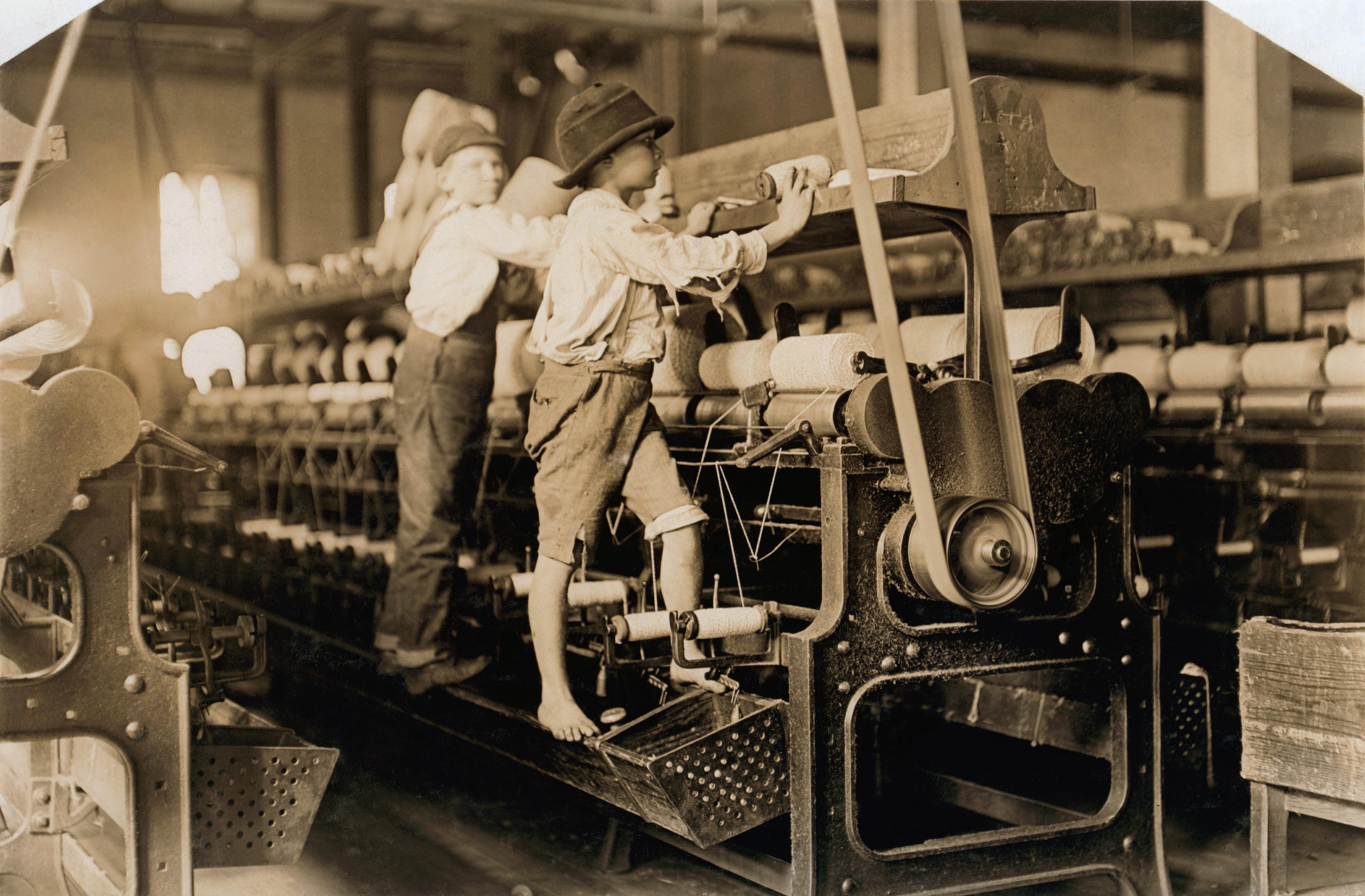 Stare, czarno-białe zdjęcie przedstawiające dzieci pracujące w fabryce
