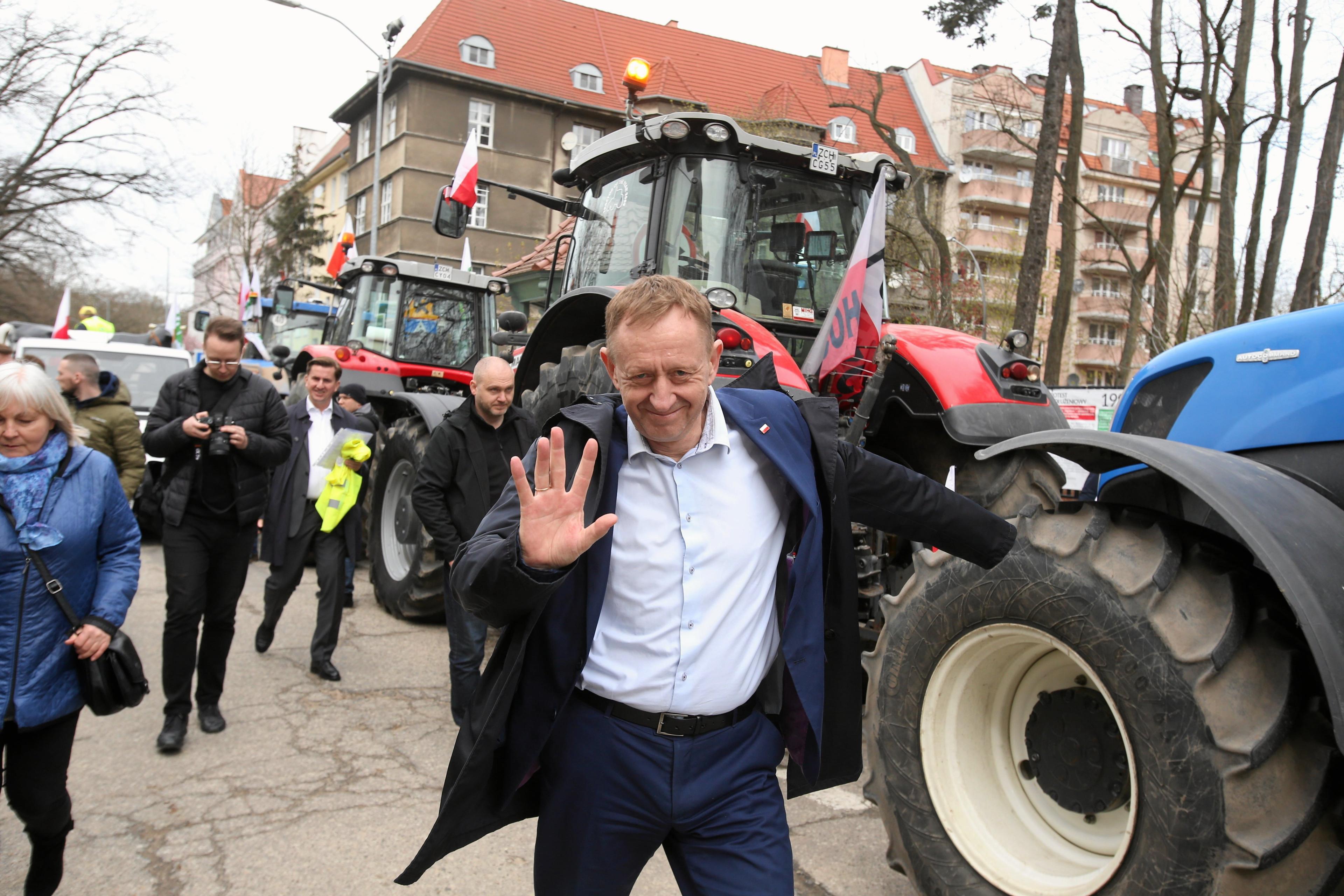 Uśmiechnięty minister Robert Telus. W tle traktor