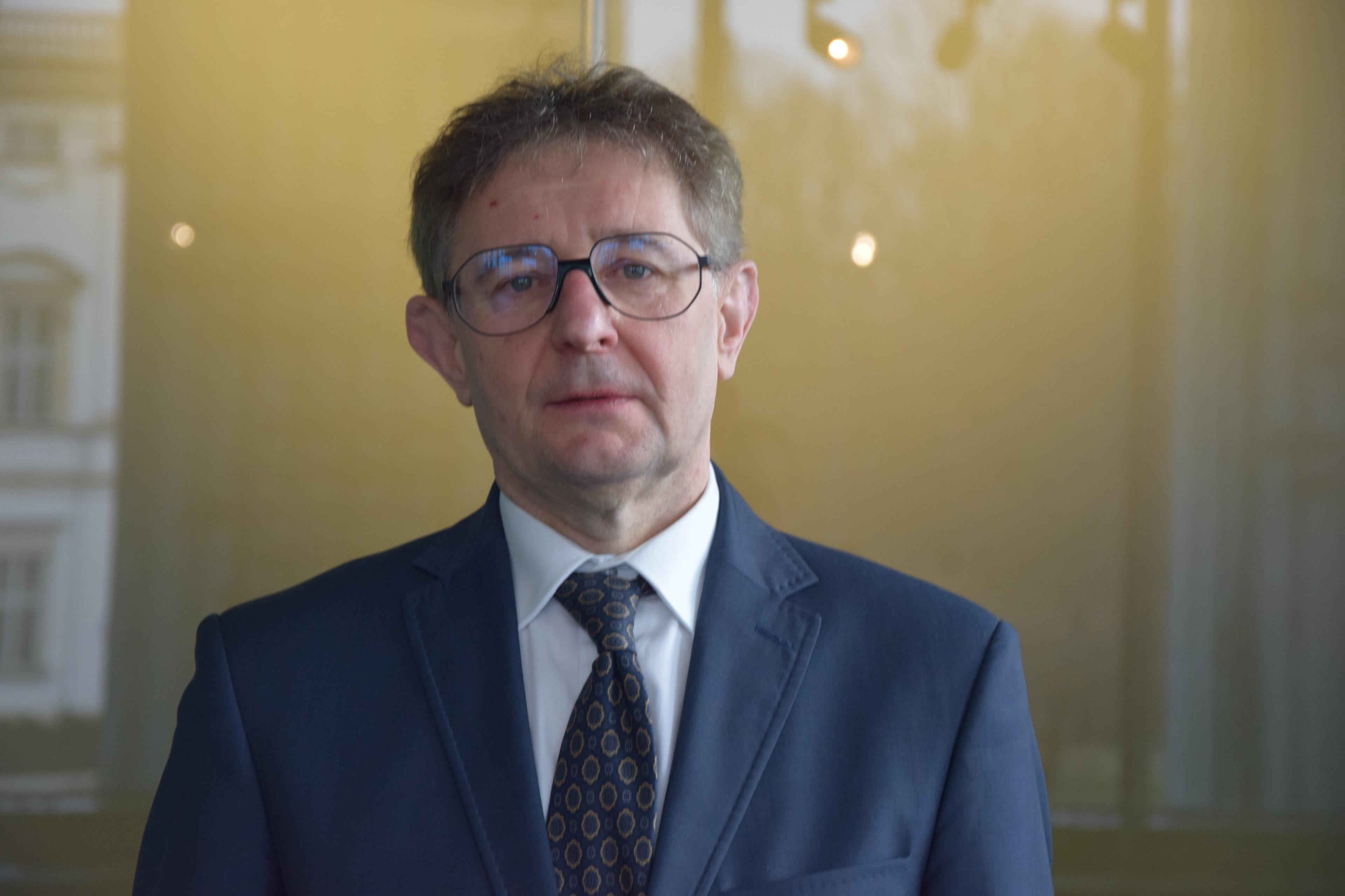 Mężczyzna w okularach, stoi, sędzia Tomasz Wojciechowski