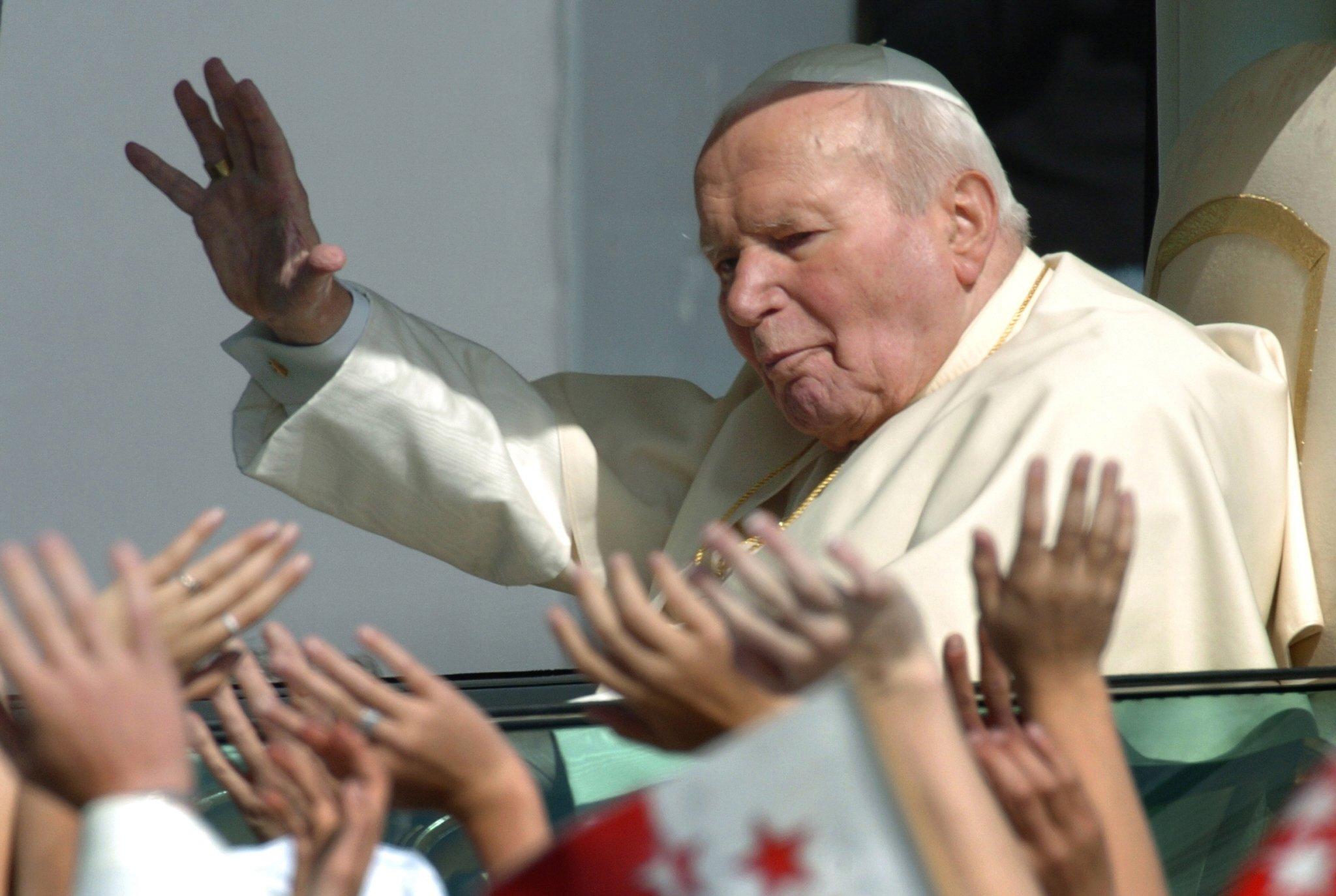 Pope John Paul II waves to a crowd of 70,000 faithfull gathered in Bern 06 June 2004. The pope launched a "pressing appeal for a commitment to unity for all Christians" amid some tensions between the Catholic and Protestant church hierarchies in Switzerland, which are equally represented in the country. AFP PHOTO MARTIN BUREAU (Photo by MARTIN BUREAU / AFP)