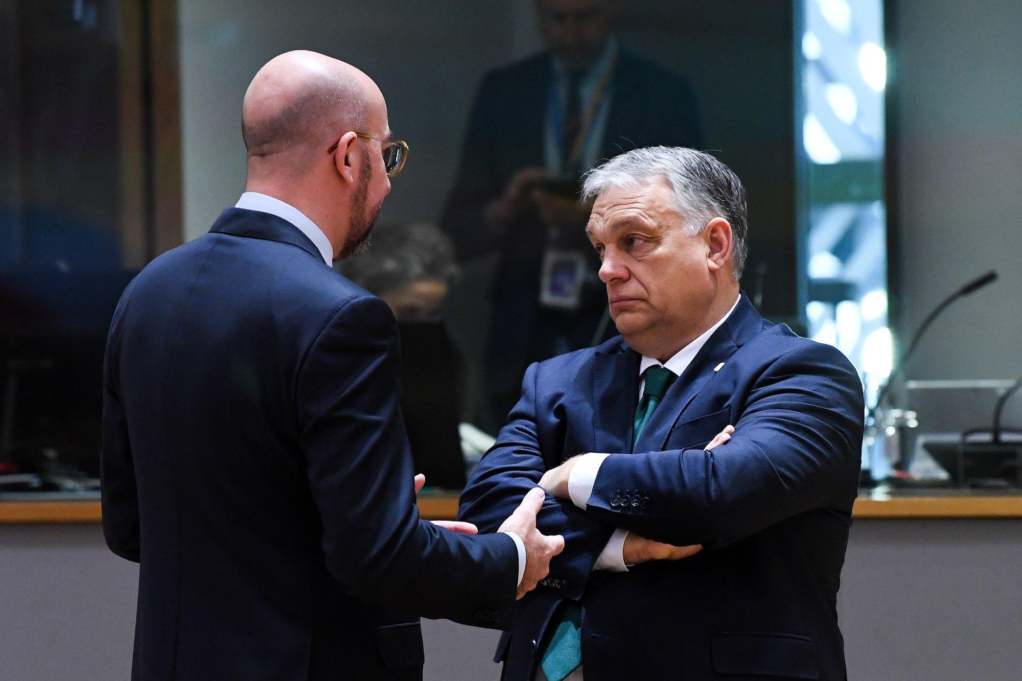Przewodniczący Rady Europejskiej Charles Michel rozmawia z węgierskim prermierem Viktorem Orbanem w siedzibie RE w Brukseli. Michel stoi tyłem, mówi coś do Organa, który patrzy w bok z założonymi rękami.
