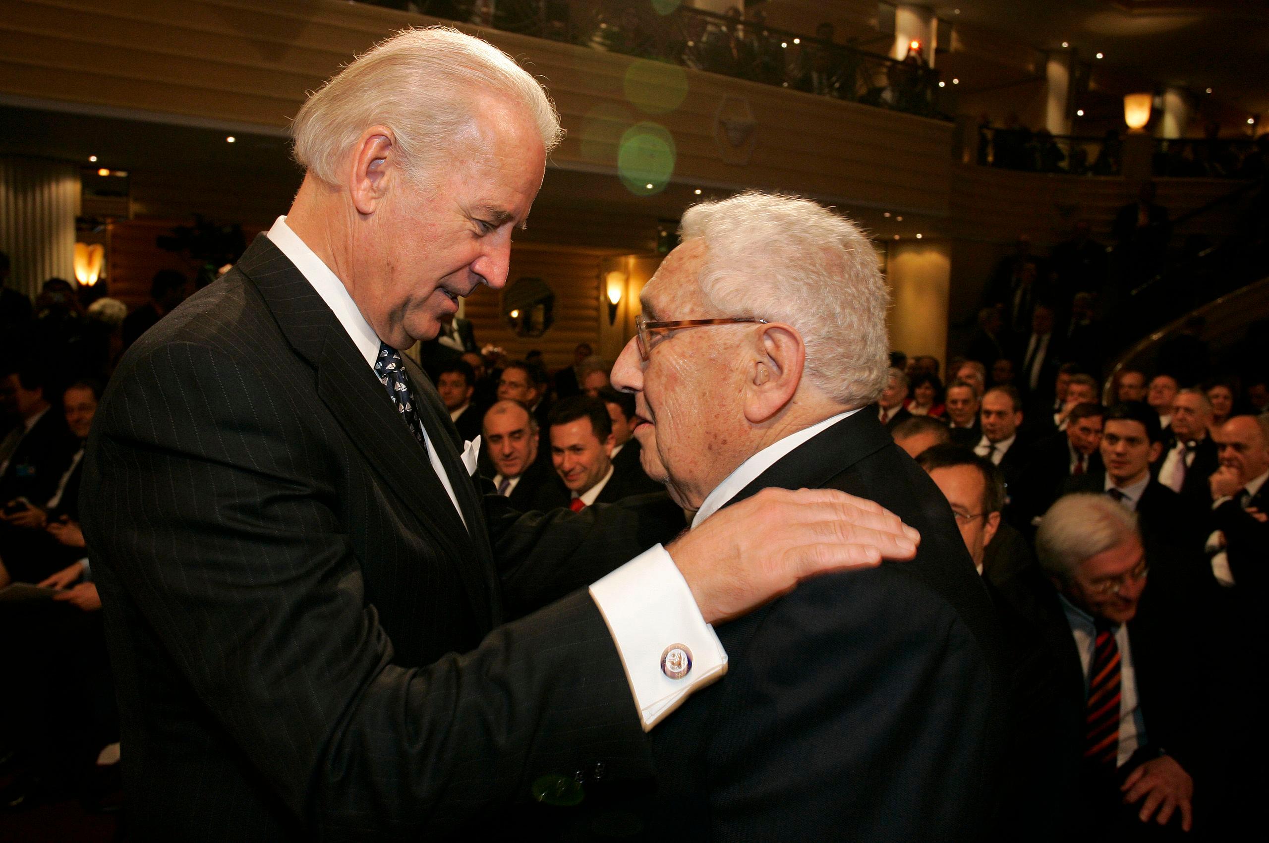 Mężczyna wyższy położył dłoń na ramieniu niższego, Biden i Kissinger