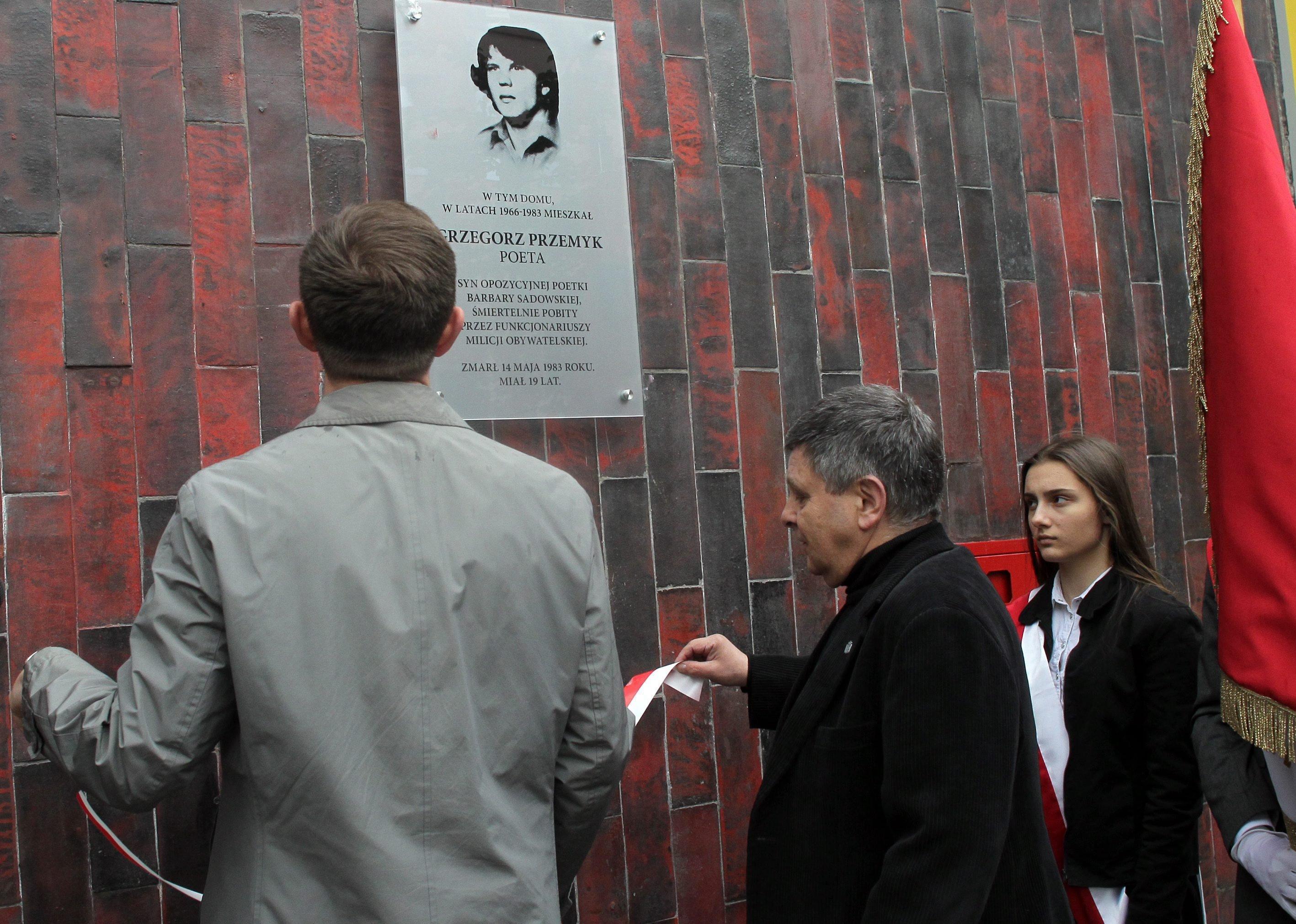 Ludzie przed tablicą pamiatkową ku czci Grzegorza Przemyka.