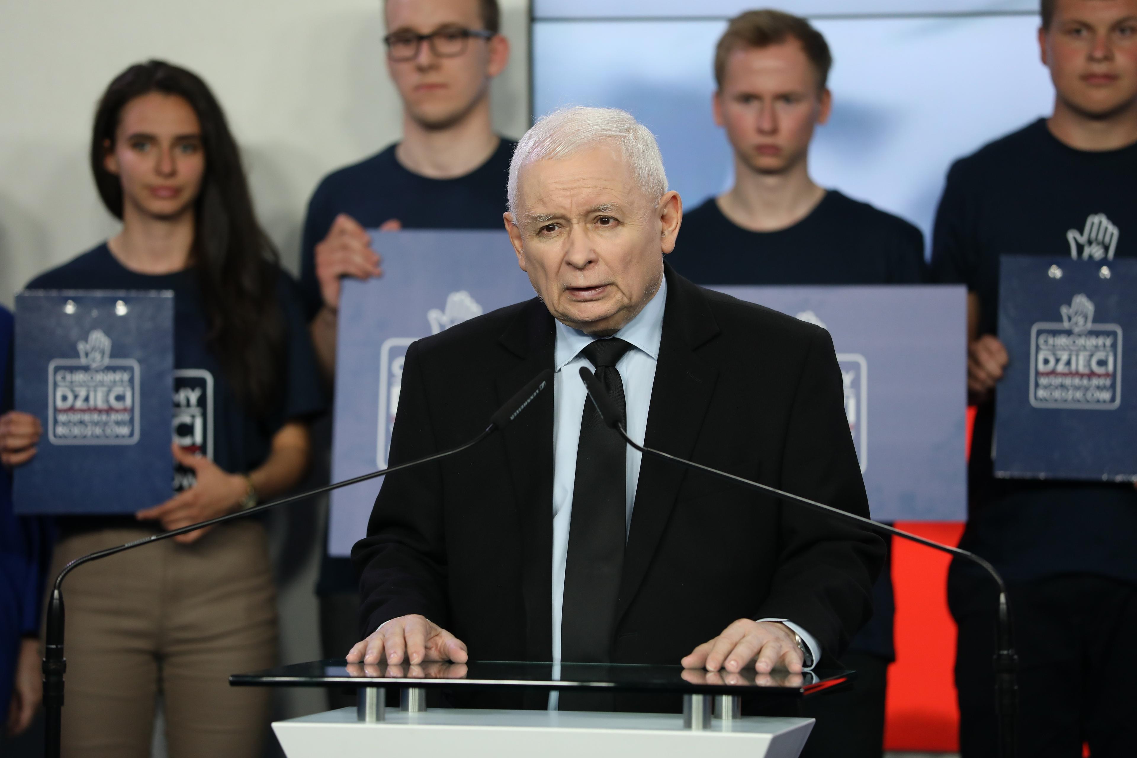 Jarosław Kaczyński stoi na tle czworga młodych osób, które trzymają plansze z napisem „Chrońmy dzieci”, 4 maja 2023