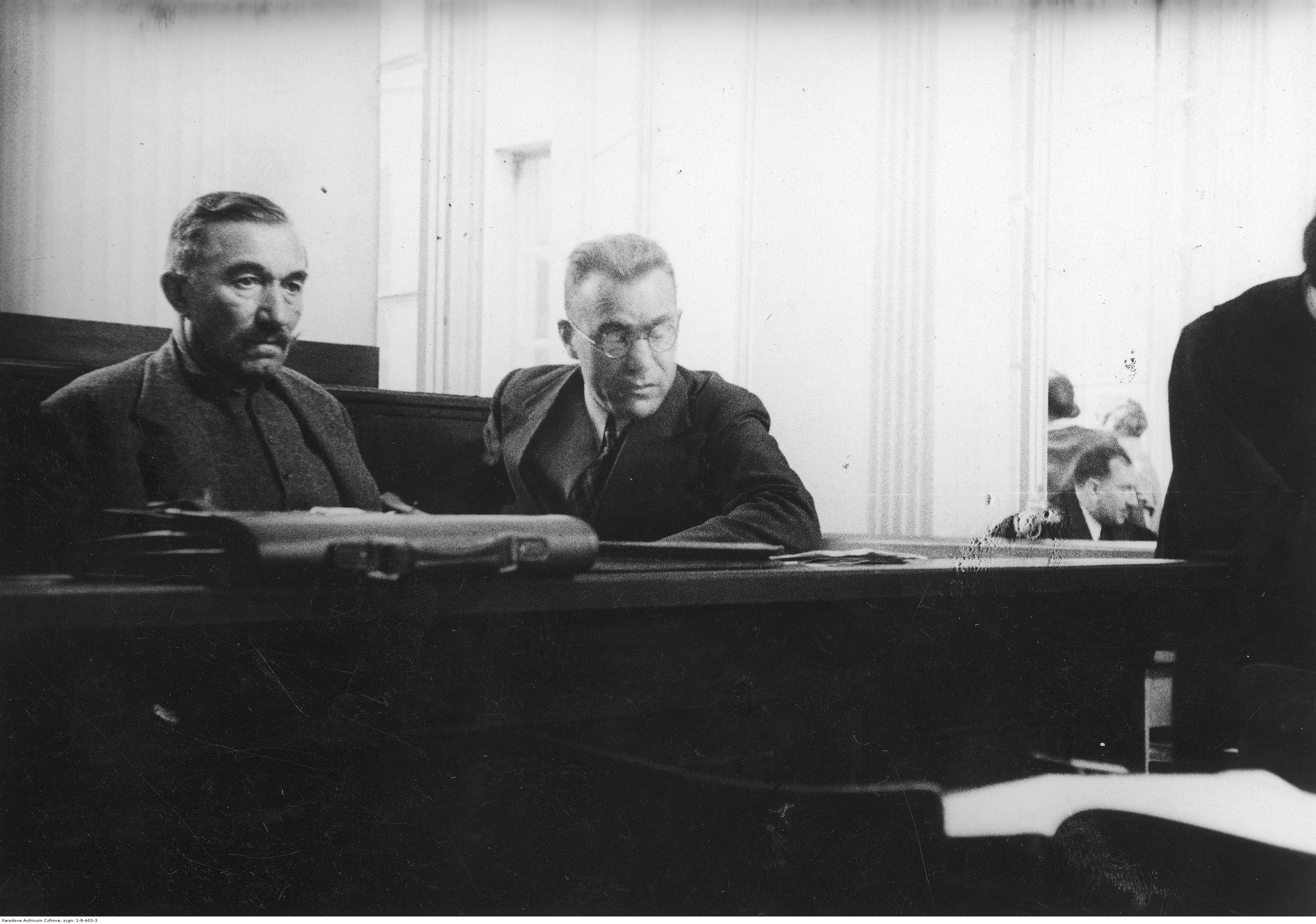 Czarno białe zdjęcie. Wincenty Witos i Kazimierz Bagiński na ławie oskarżonych