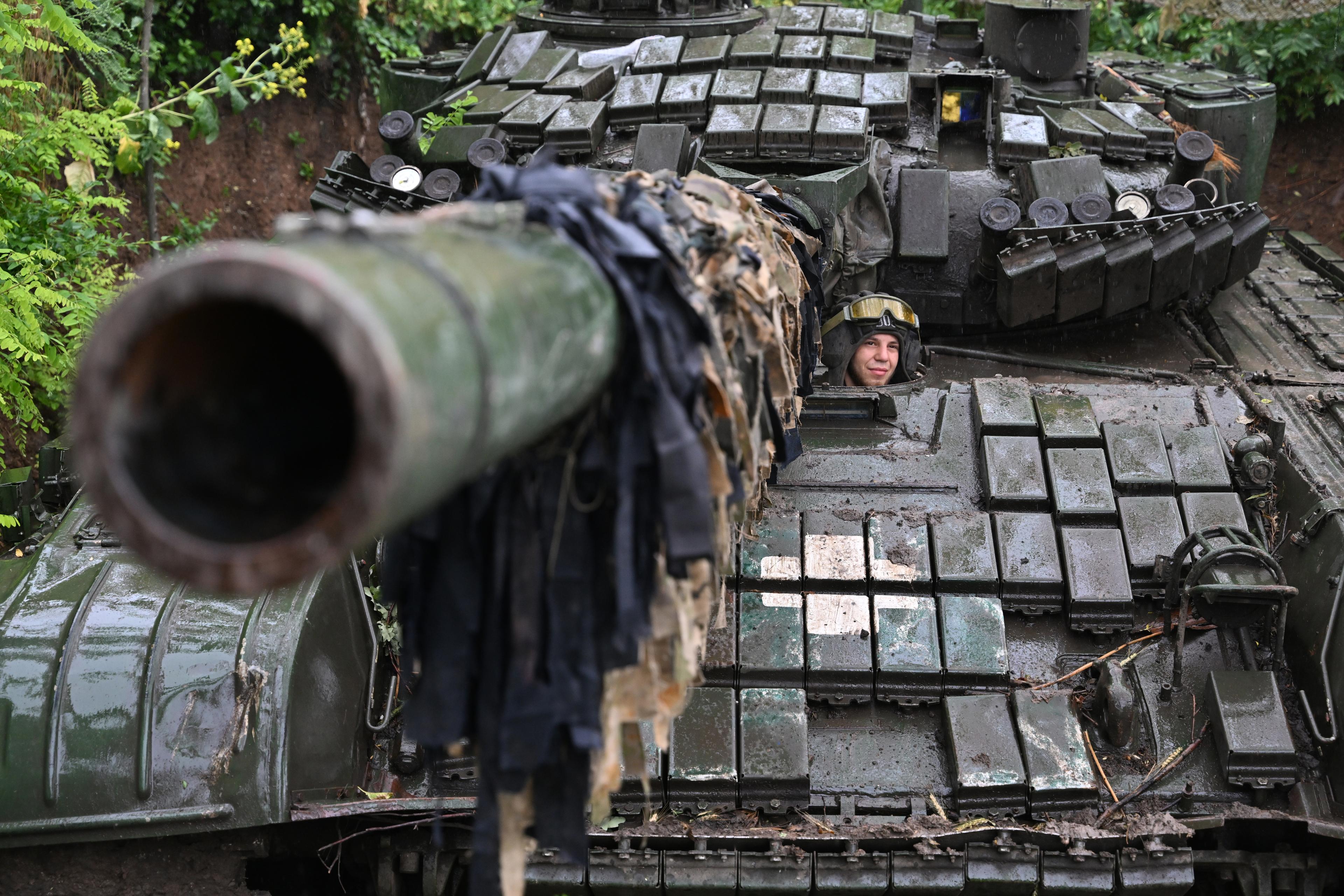 Żołnierz ukraiński we włazie czołgu T-72. Lufa zwrócona w stronę obiektywu