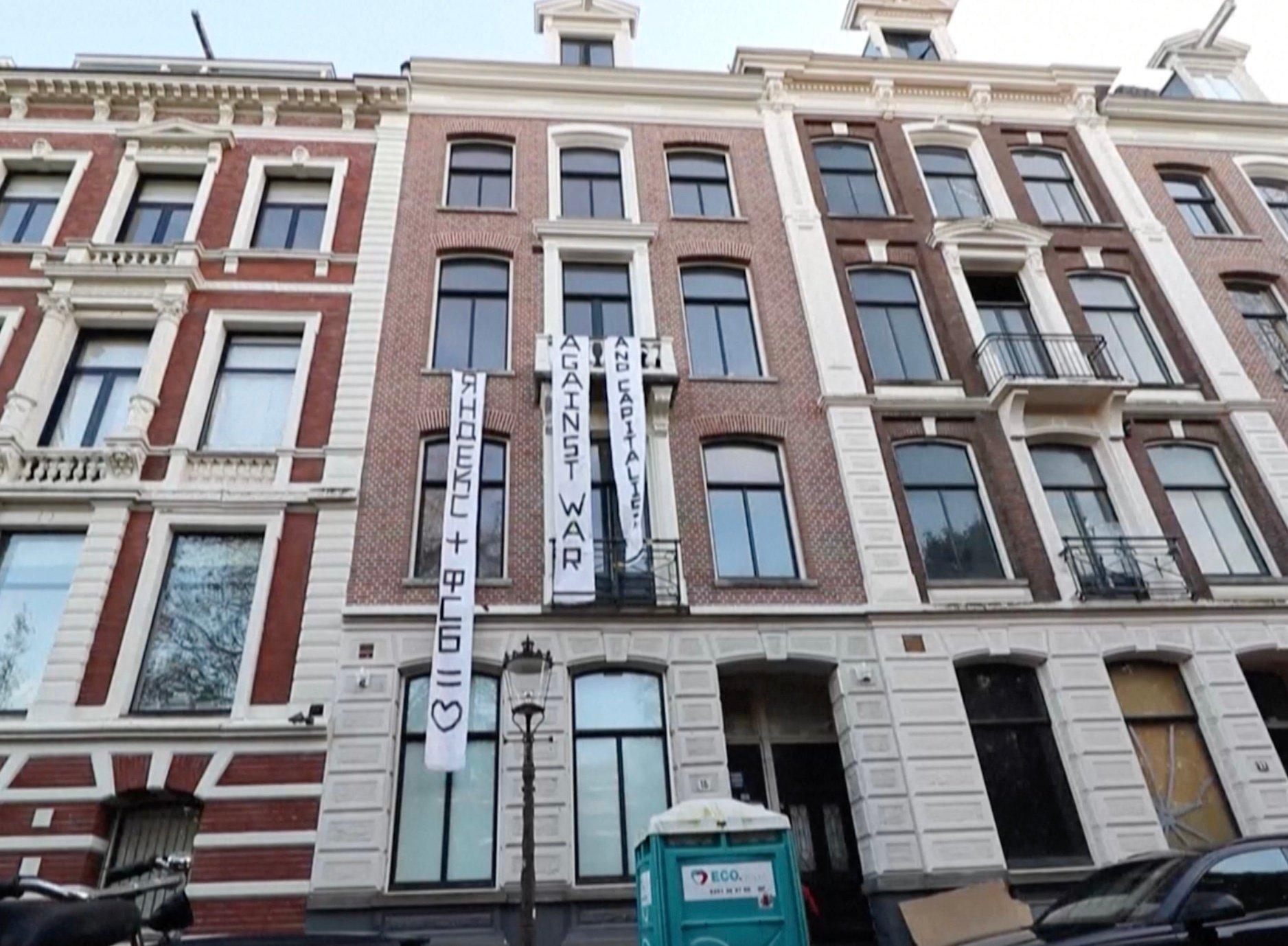 Kamienice w Amsterdamie, na jednej z nich pionowy transparent w j. rosyjskim: Yandex + FSB = znak serca. SŻlotersi z Amsterdamu zajęli kamienicę rosyjskiego oligarchy.
