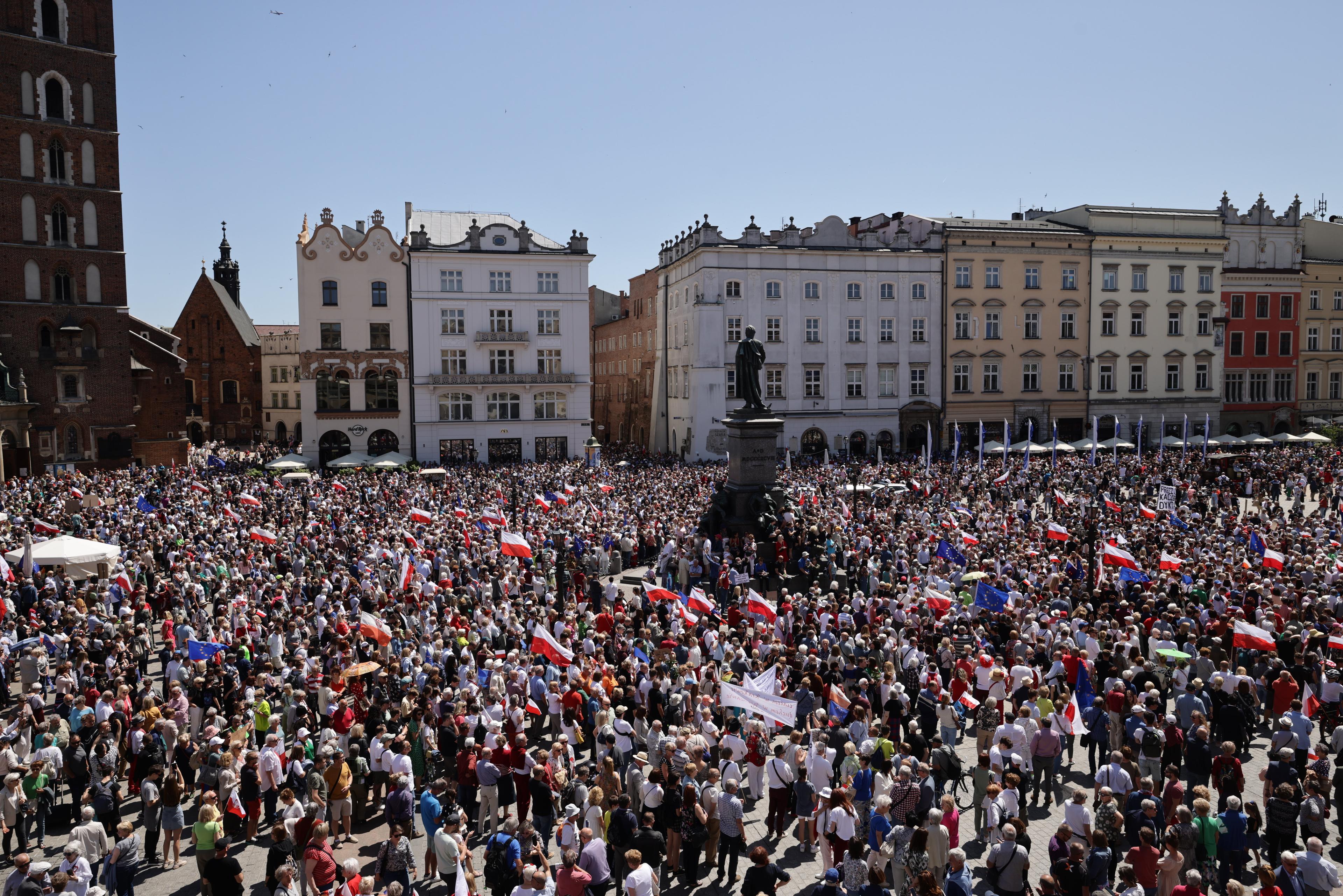 Rynek w Krakowie wypełniony ludźmi z biało-czerwonymi flagami