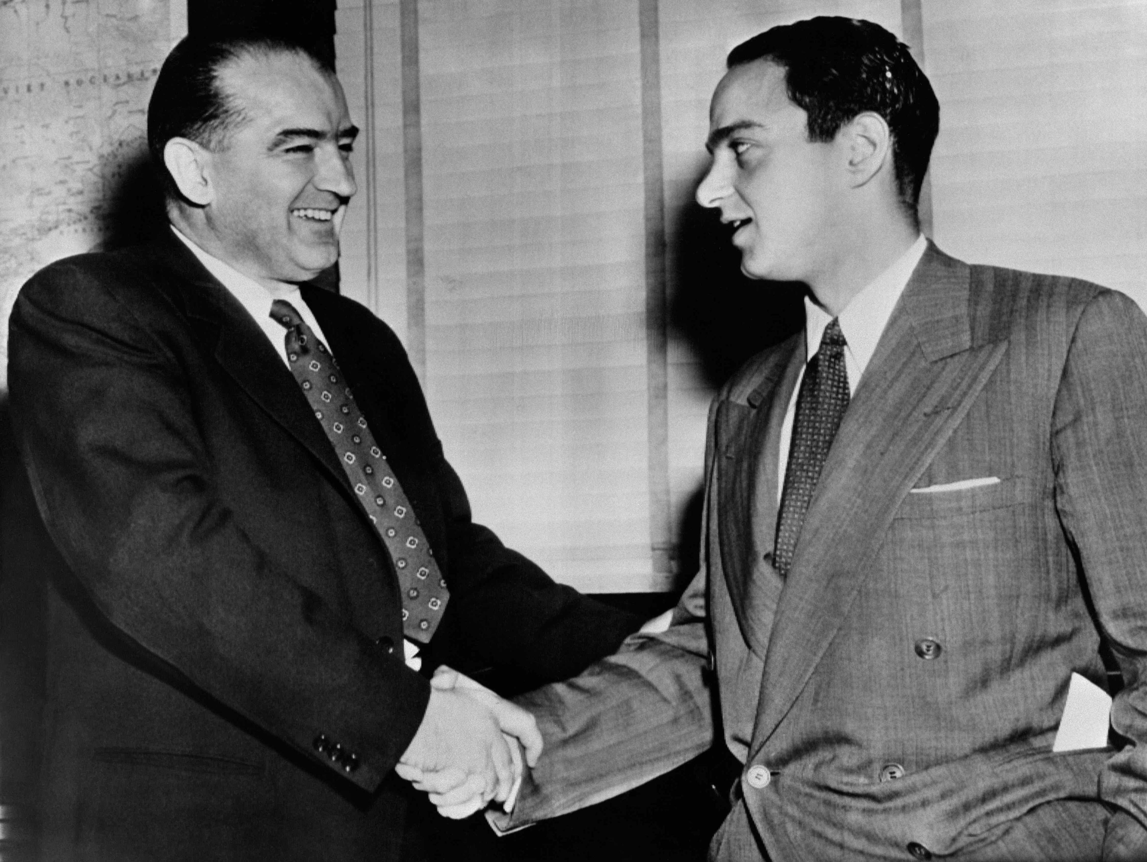 Czarno-białe zdjęcie przedstawiające dwóch mężczyzn w garniturach, którzy podają sobie ręce. Joseph McCarthy