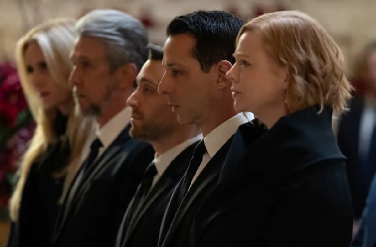 Dwie kobiety i trzech mężczyzn stoi w jednym rzędzie w kościele. Rodzina Logana Roya podczas pogrzebu. Serial „Sukcesja”