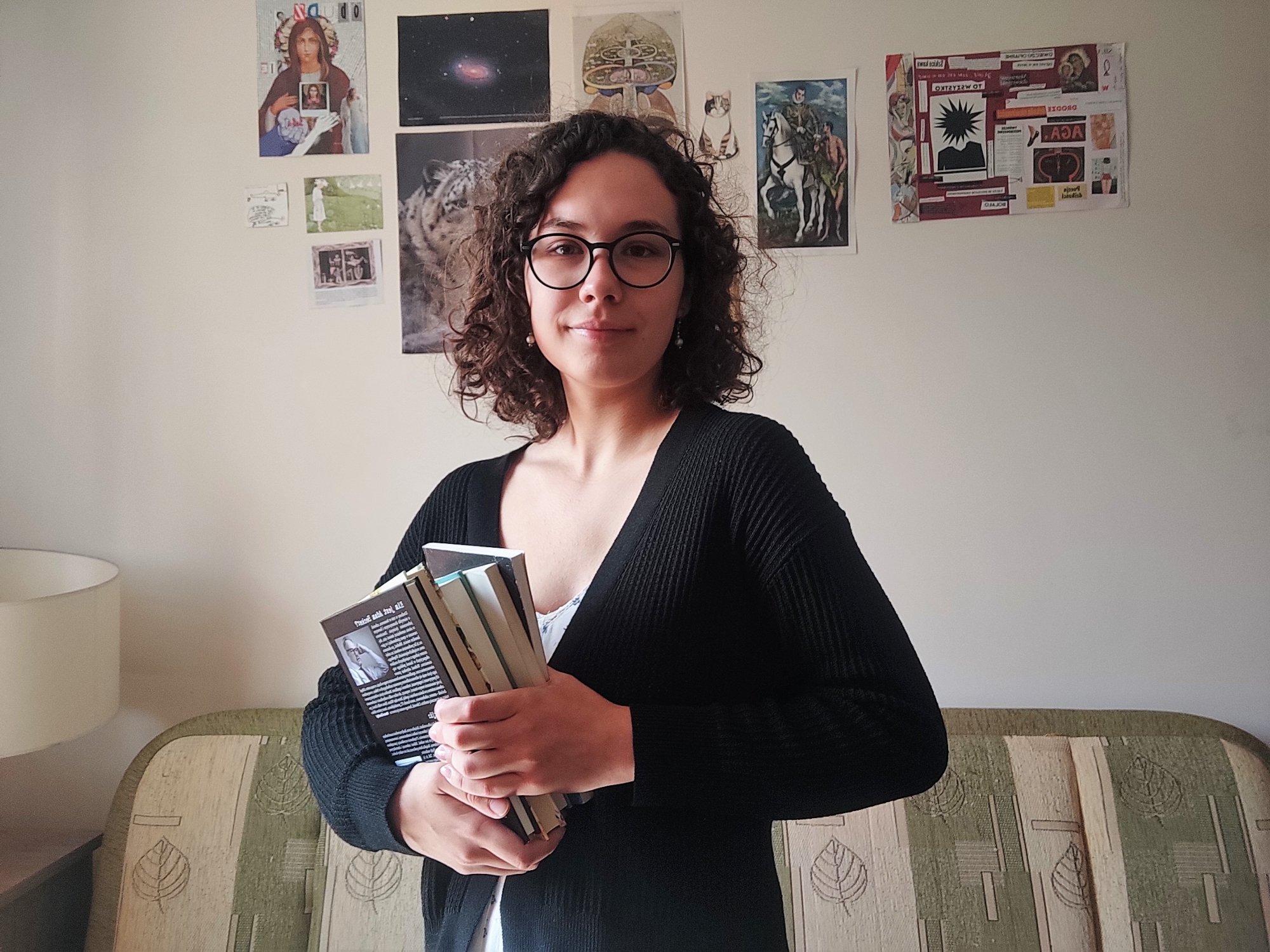 Młoda kobieta w okularach z książkami w ręku