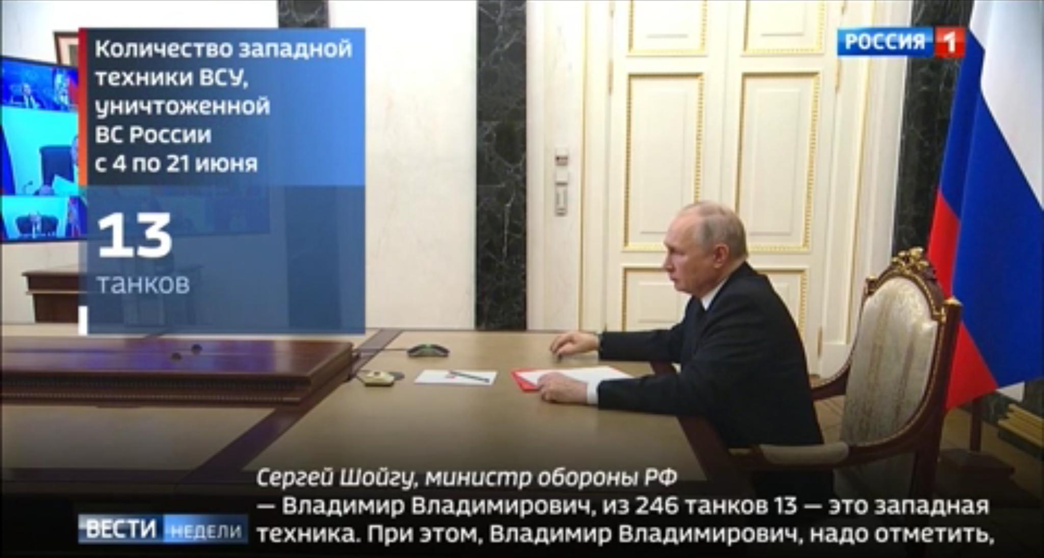 Putin (starszy mężczyzna) patrzy na ekran z którego mówi Szojgu. Nie widać go jednak, bo telewizja przysłoniła go wielkim napisem "13"