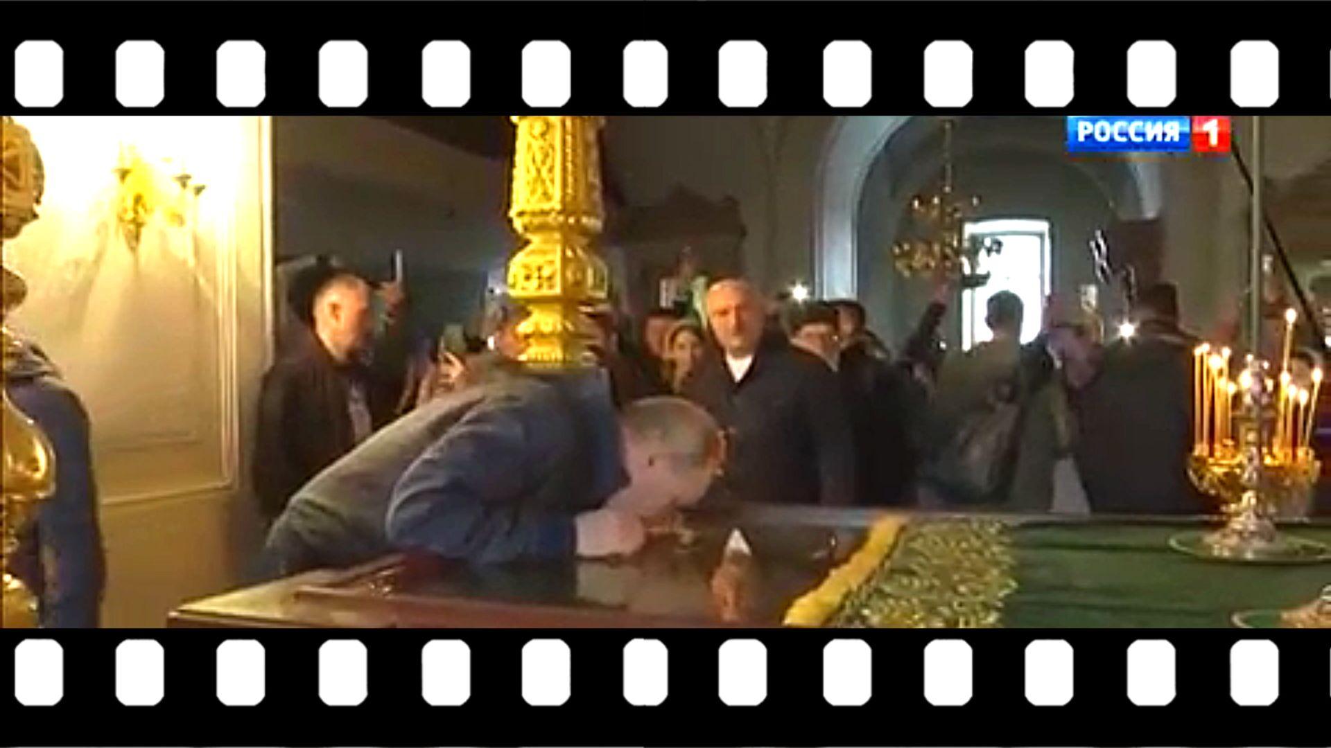 Putin w cerkwi pochyla się i całuje grób