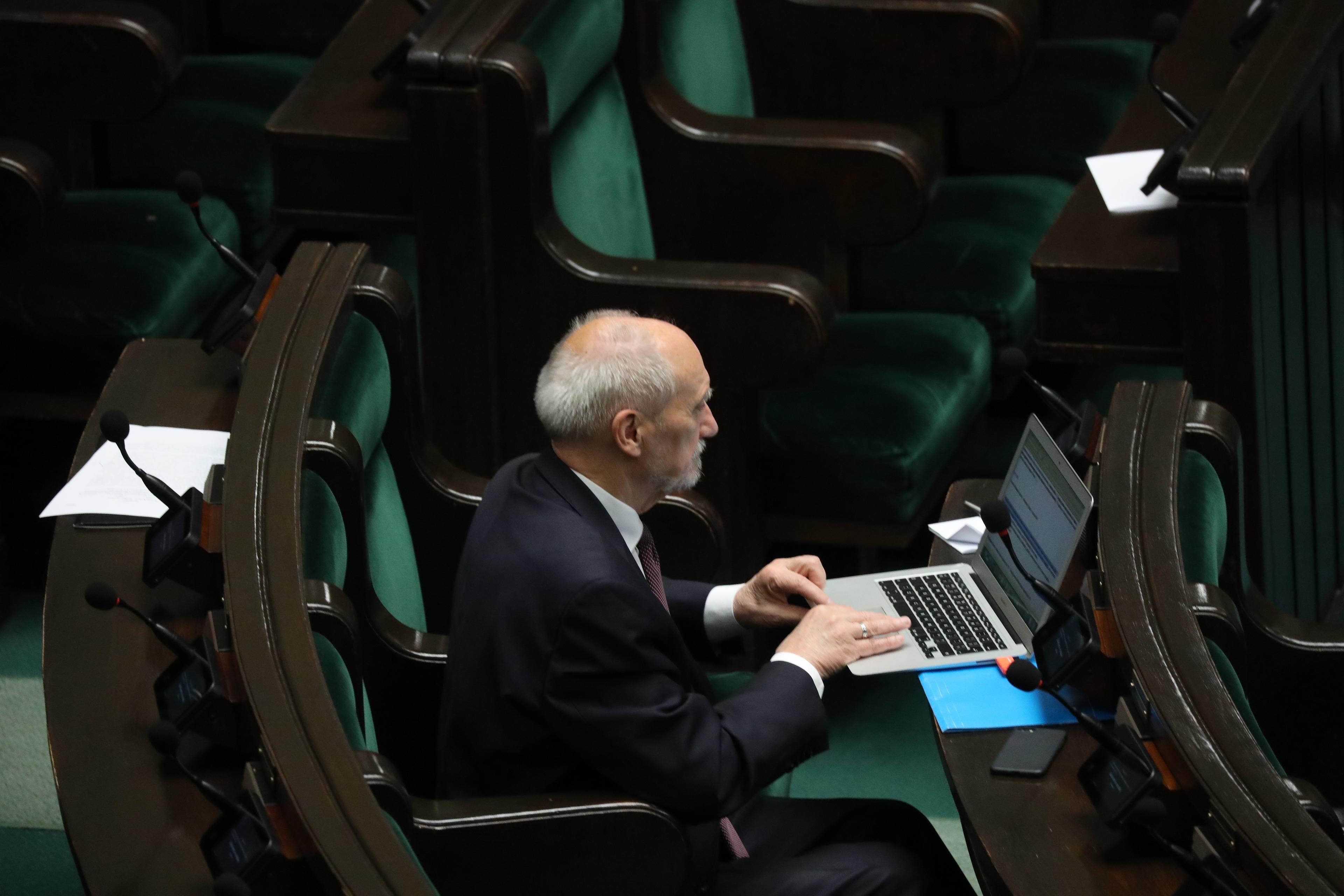 Starszy mężczyzna (Antoni Macierewicz) patrzy w komputer w ławie sejmowej w czasie debaty o Lex Tusk 16 czerwca 2023