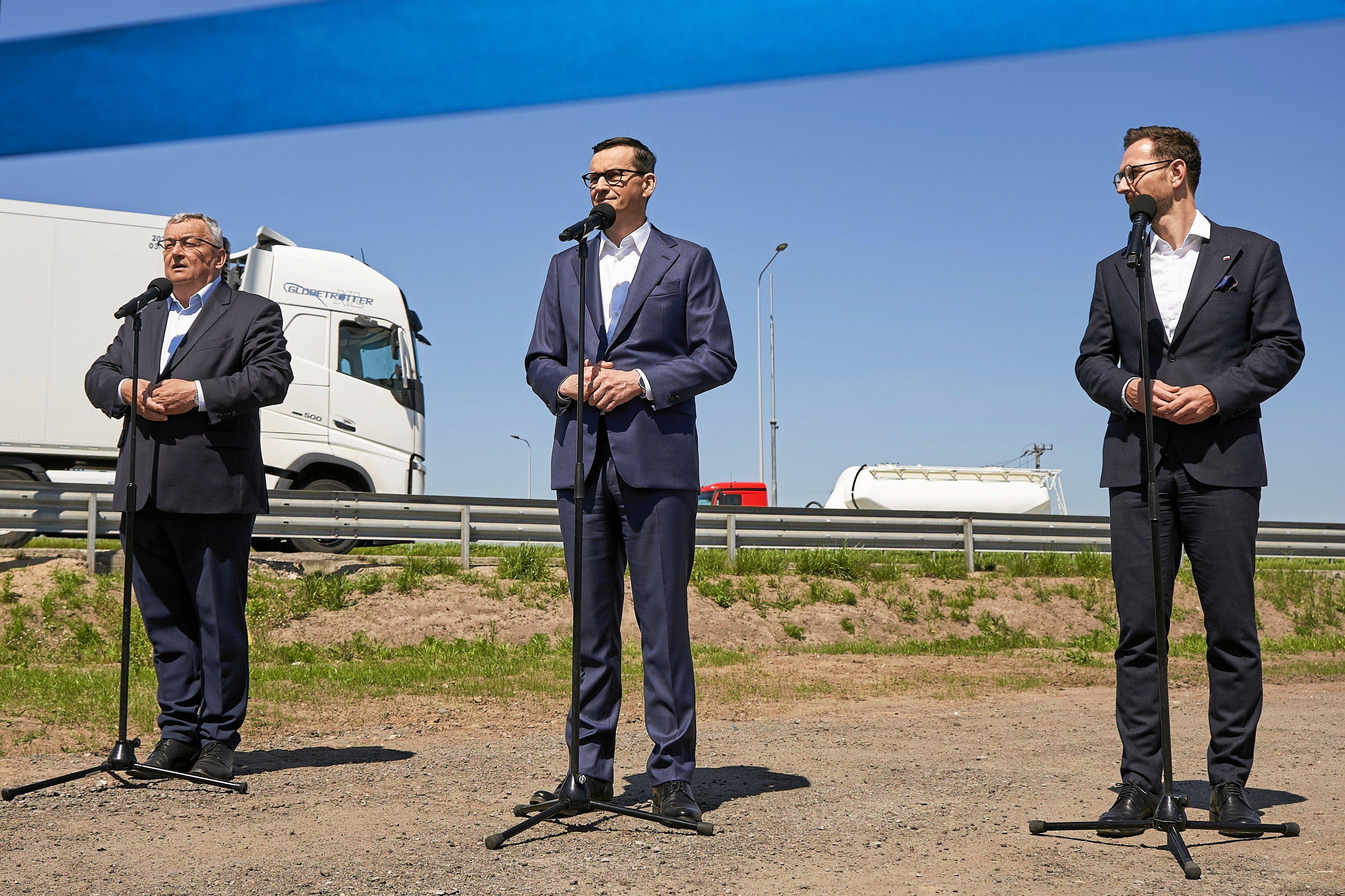 Mateusz Morawiecki, minister infrastruktury Andrzej Adamczyk i minister rozwoju Waldemar Buda stoją przy autostradzie