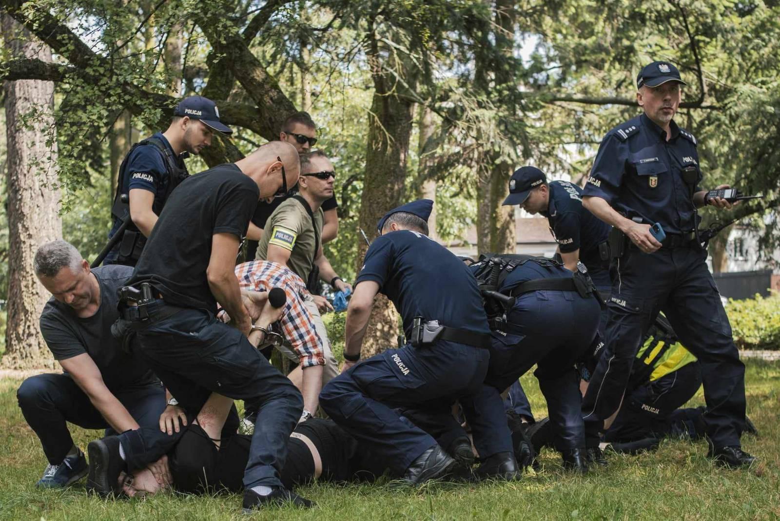 Tłum policjantów przyciska do ziemi osobę