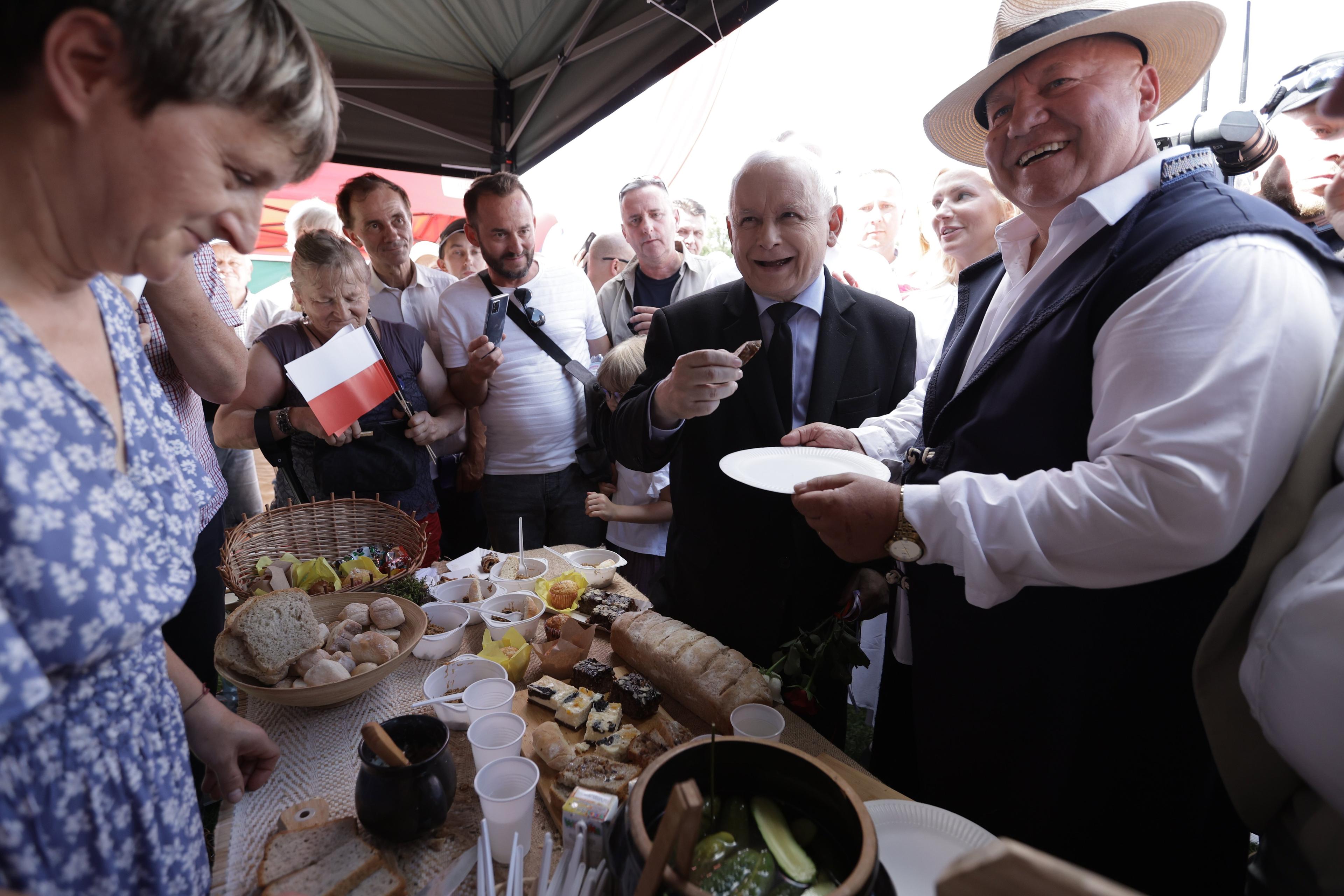Kaczyński zadowolony w tłumie przy stole z regionalnymi przysmakami