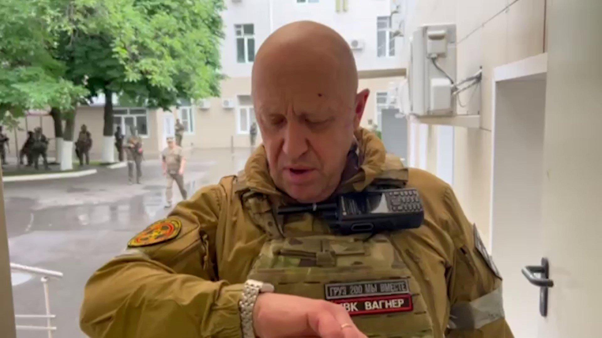 Mężczyzna, Jewgienij Prigożin, patrzy na zegarek, jest w wojskowym uniformie bojowym