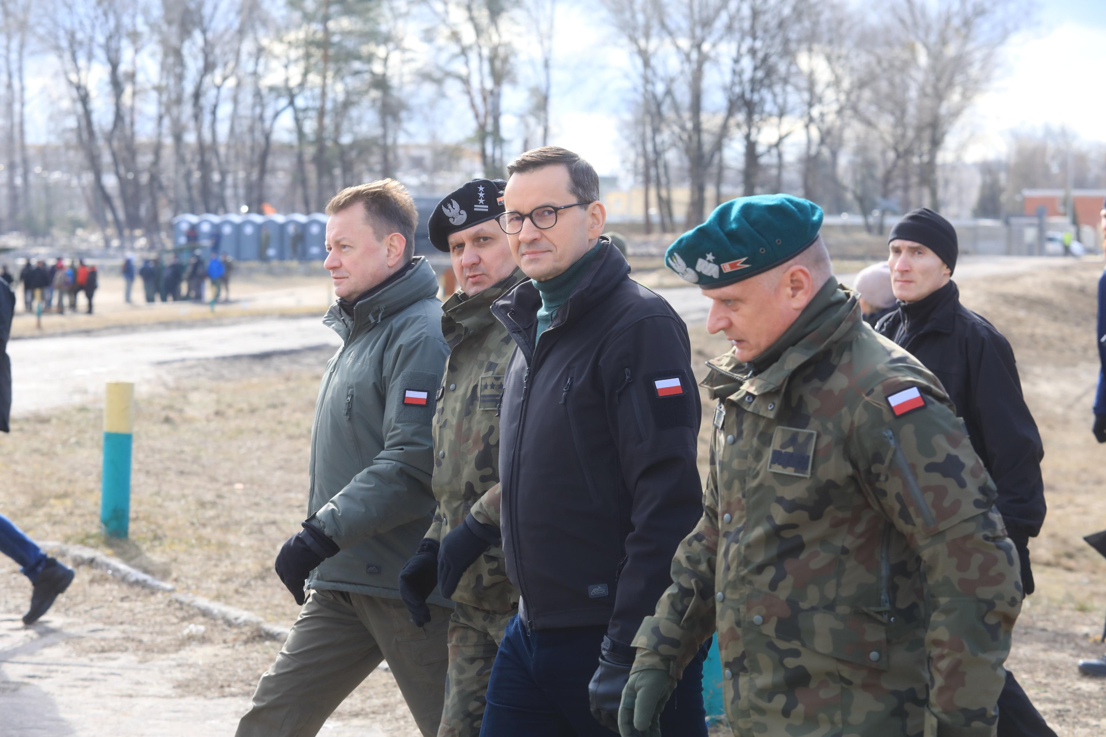 Morawiecki i Błaszczak idą w towarzystwie dwóch wojskowych