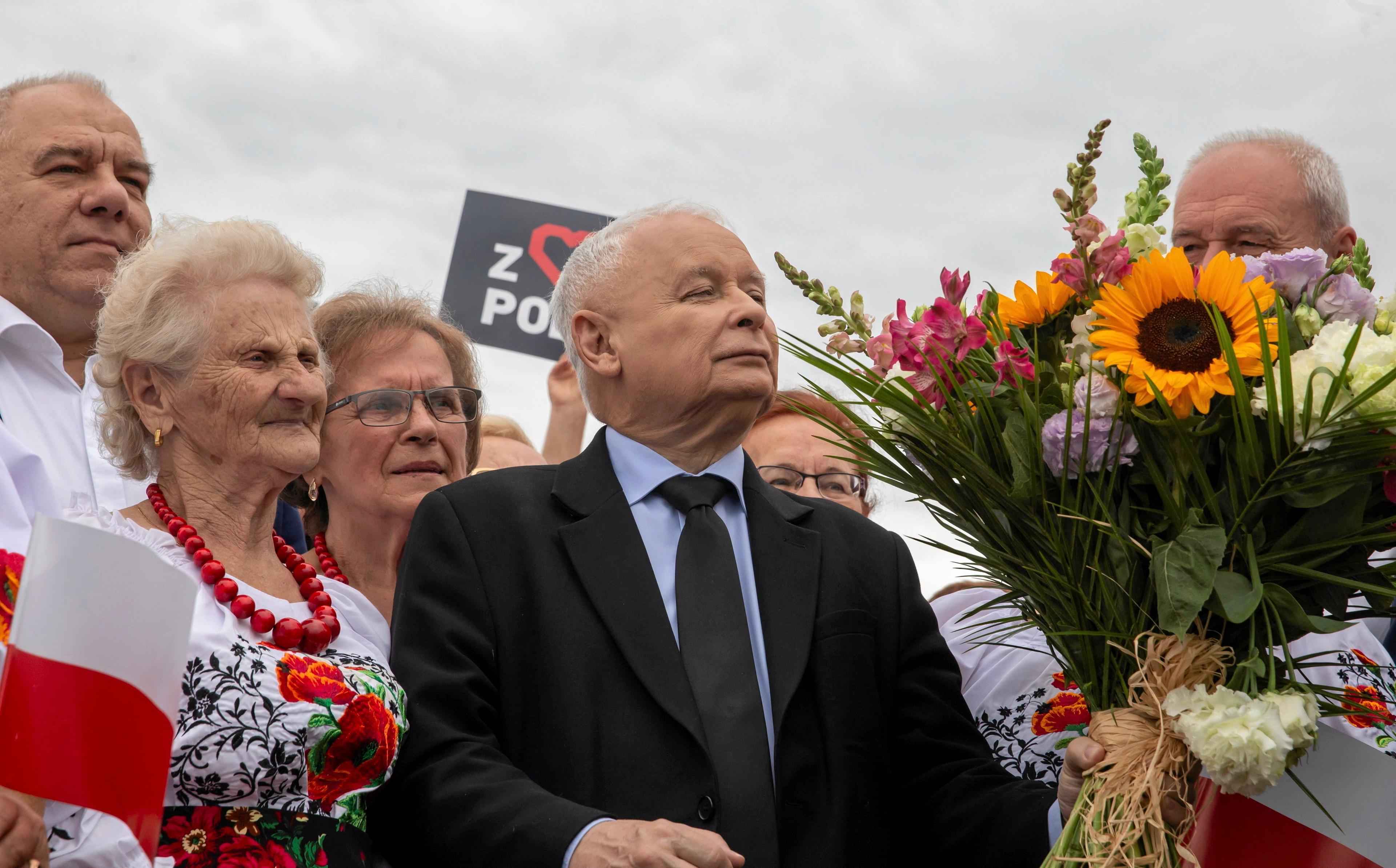 Dumny Jarosław Kaczyński oczekuje na wręczenie bukietu kwiatów podczas pikniku
