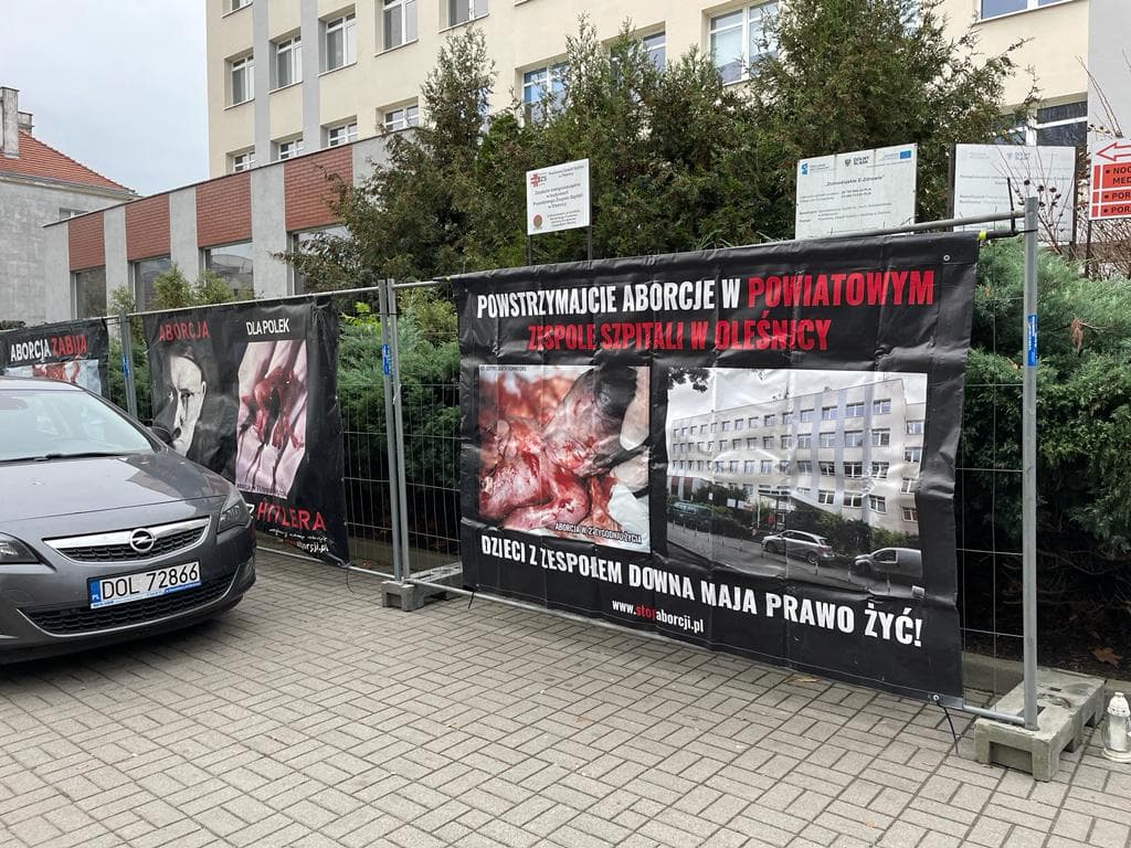 Banery powieszone na płocie nawołujące do zaprzestania aborcji w szpitalu w Oleśnicy