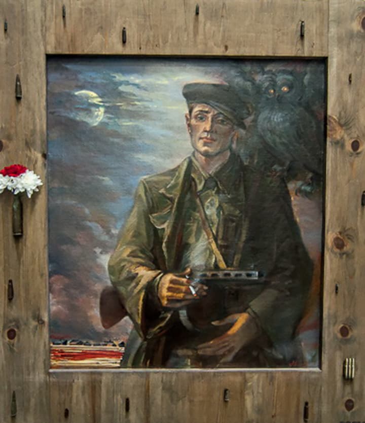 Portret partyzanta, trzymającego broń na ramieniu i palącego papierosa