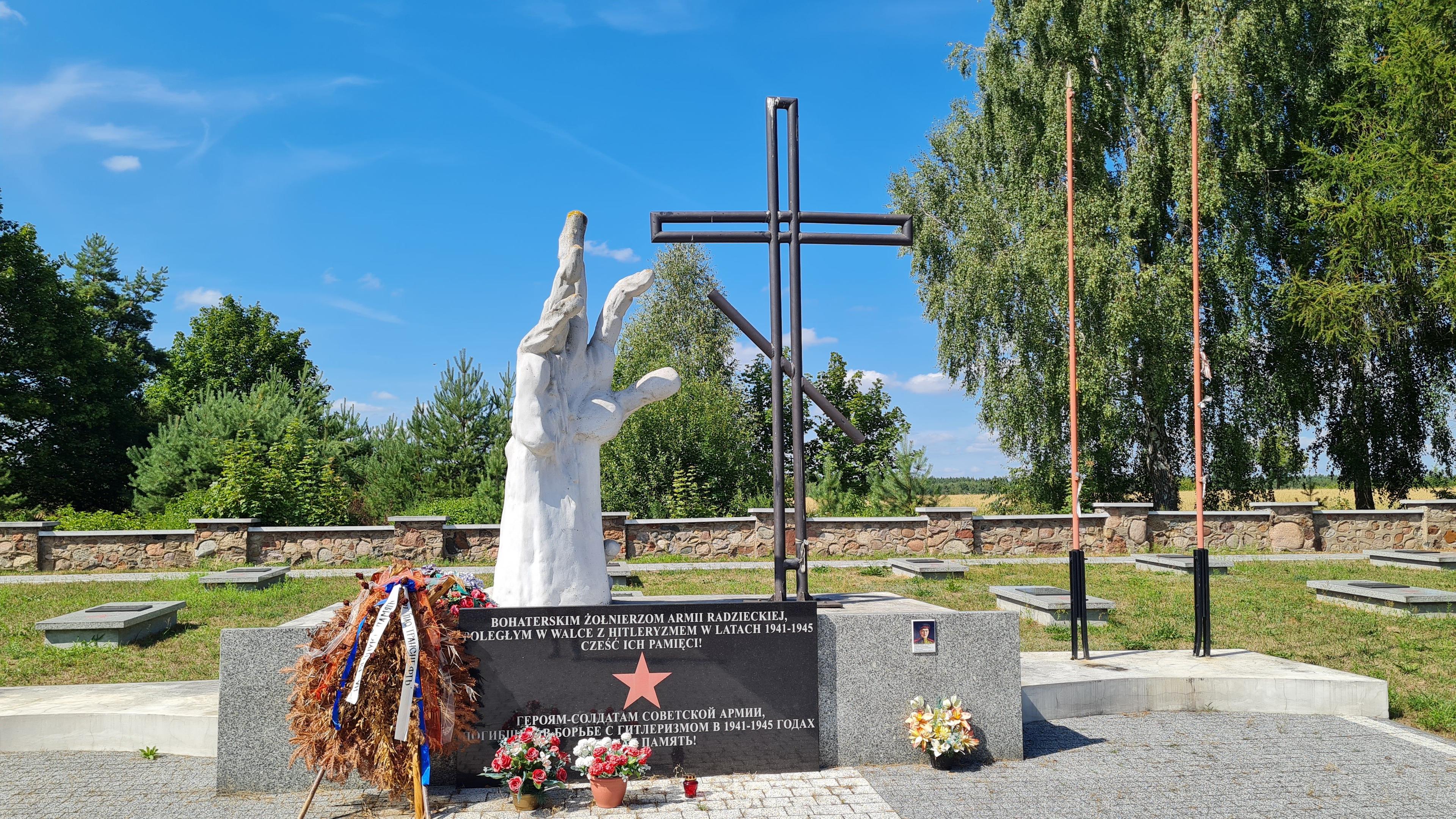 Pomnik na cmentarzu żołnierzy radzieckich przedstawiający złożone dłonie, krzyż prawosławny, na postumencie czerwona gwiazda oraz napis „Bohaterskim żołnierzom radzieckim poległym w walce z hitleryzmem w latach 1941-1945”