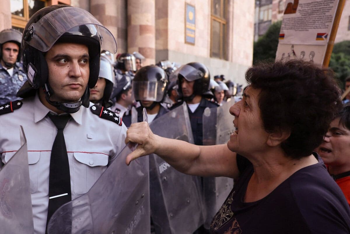 Kobieta krzyczy na armeńskich policjantów podczas demonstracji przed siedzibą rządu w Erywaniu