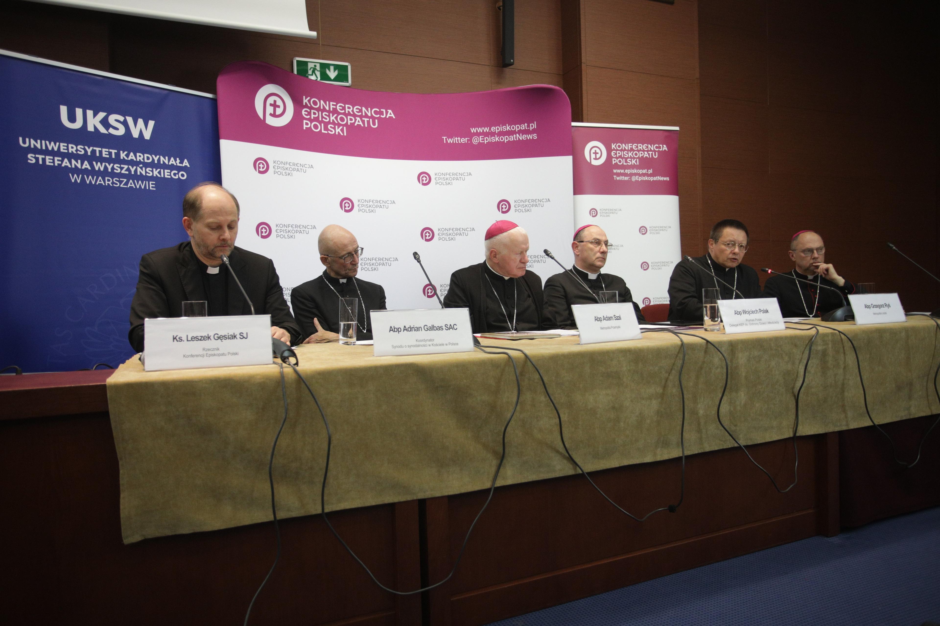 Członkowie Episkopatu siedzą przy stole podczas konferencji prasowej