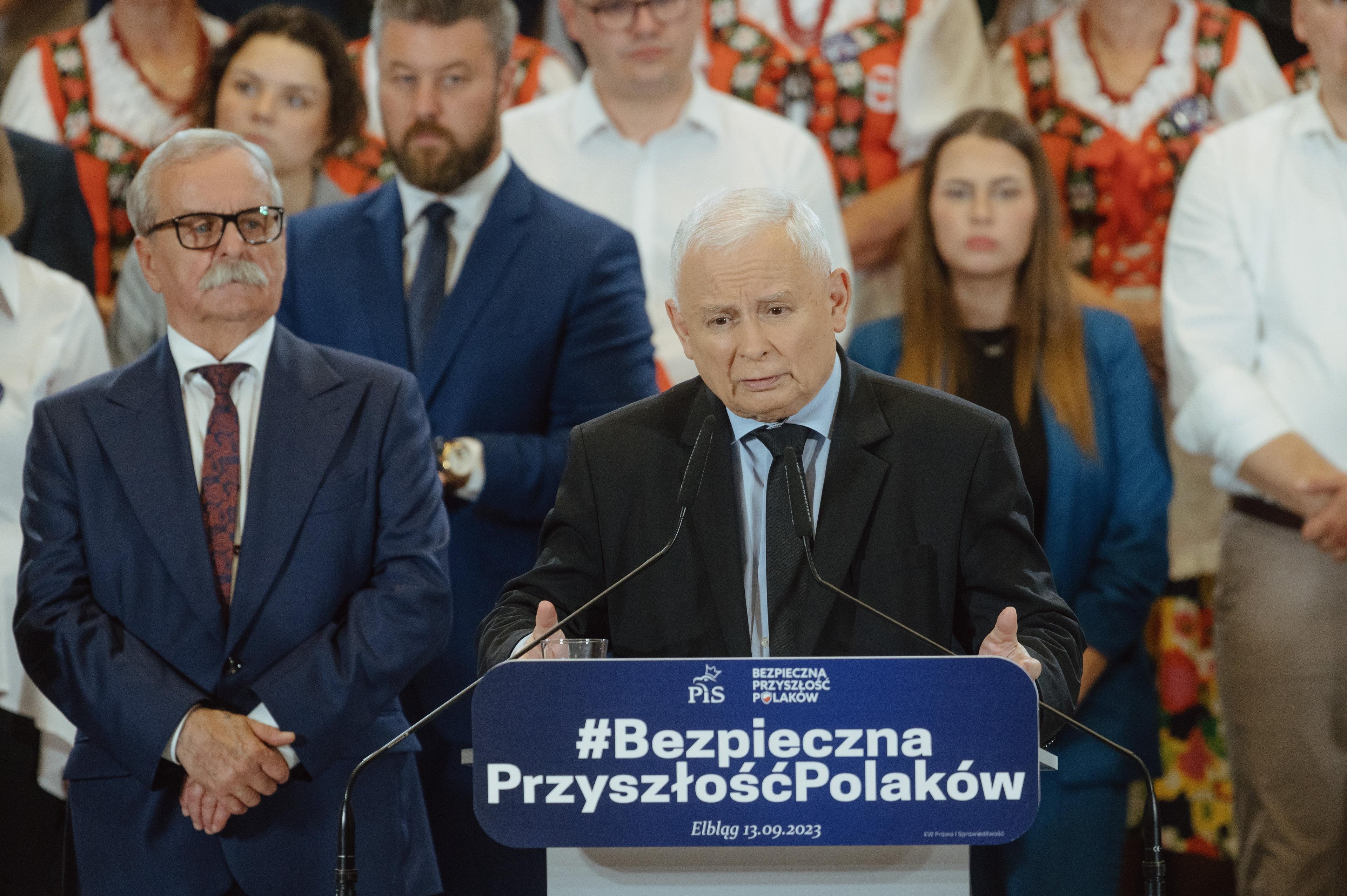 Jarosław Kaczyński przy mównicy, w tle politycy PiS