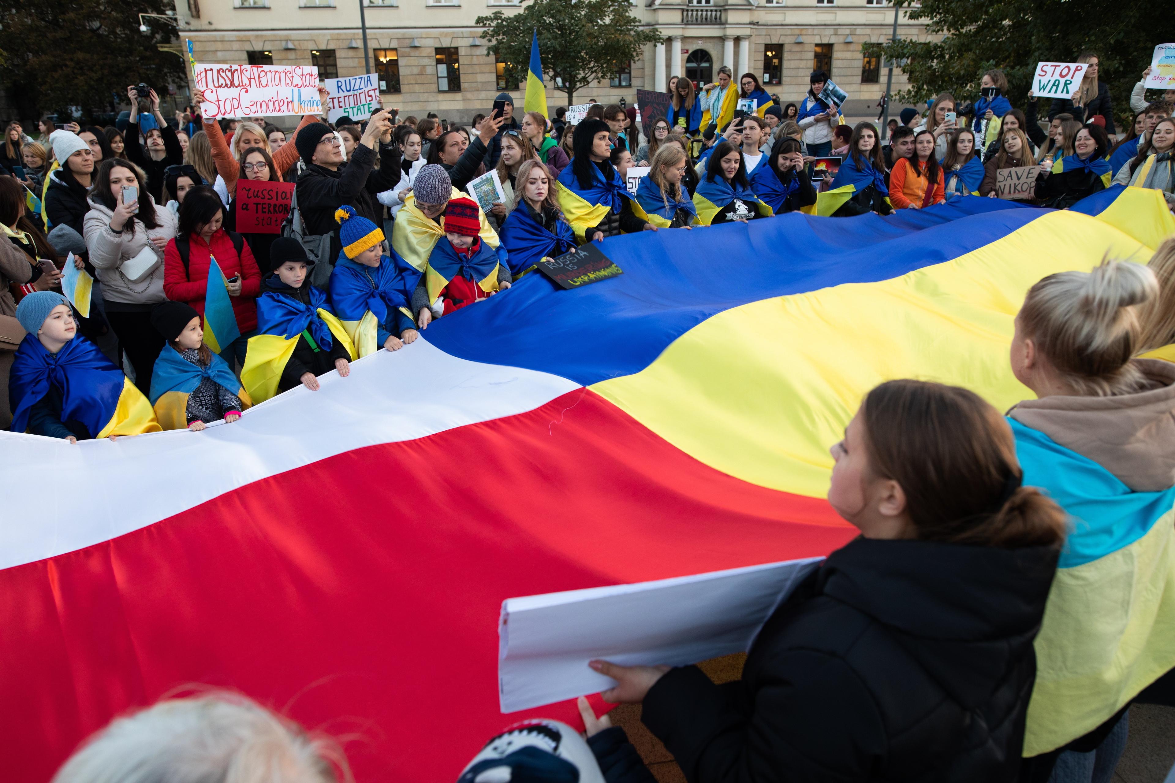 dwie wielkie flagi - polska i ukraińska niesione przez ludzi