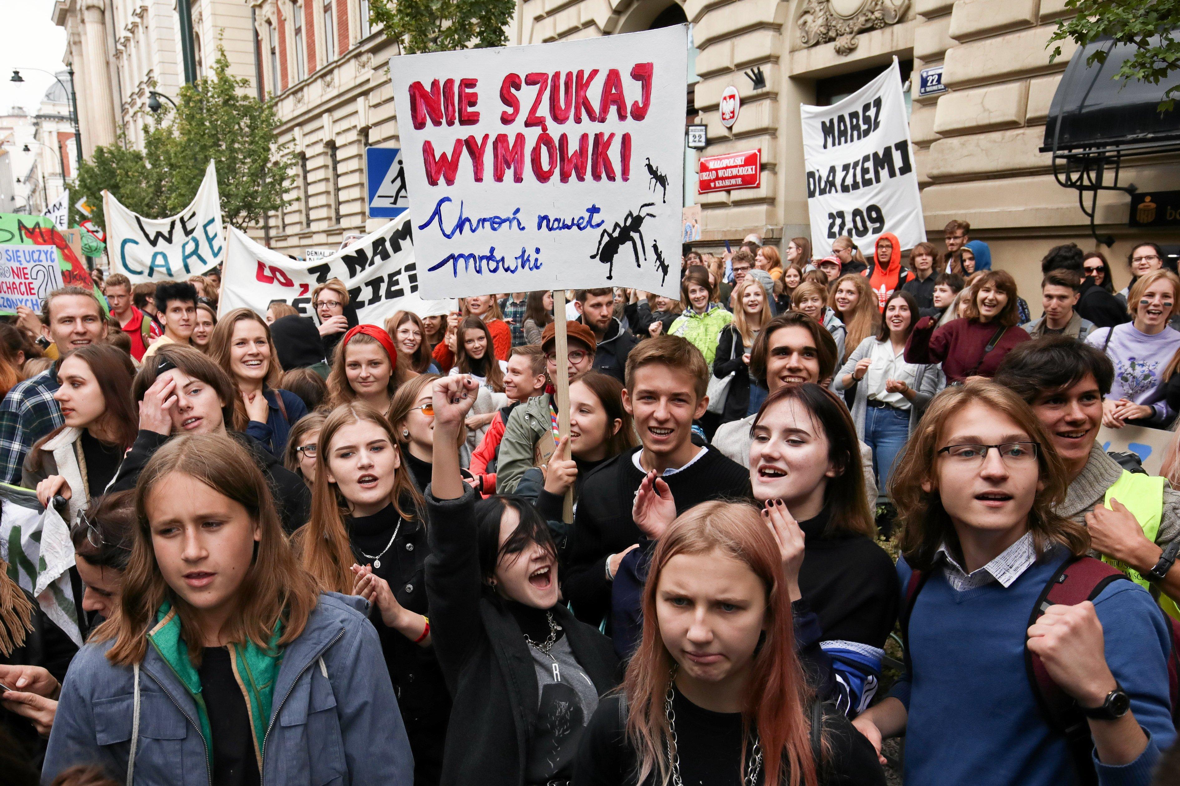 Tłum młodych ludzi na ulicy, nad nimi transparent z napisem "Nie szukaj wymówki"